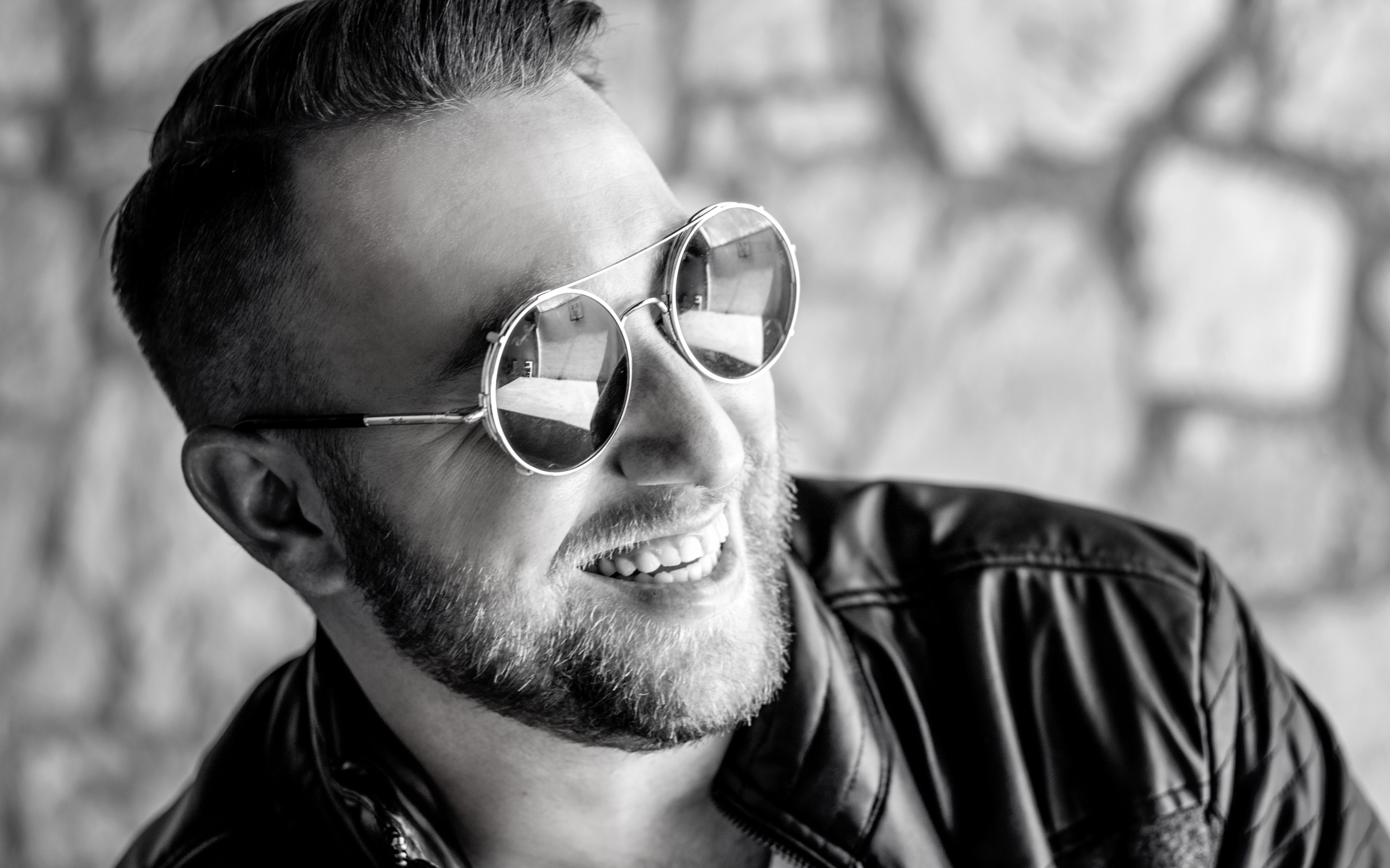 Улыбающийся брутальный мужчина в черных очках