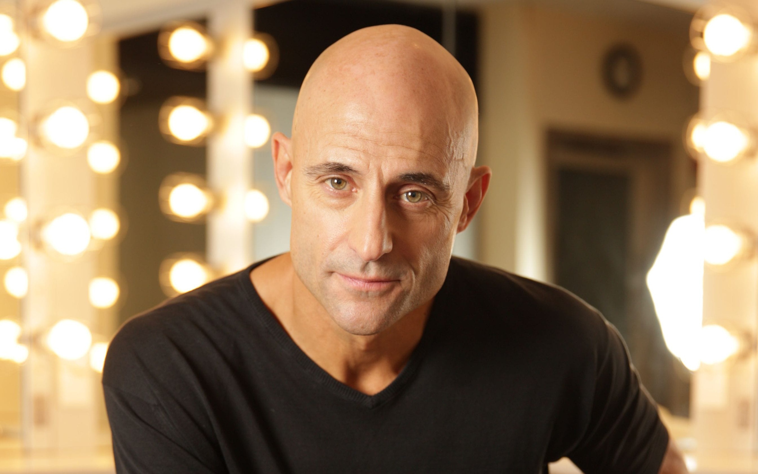 Актер Марк Стронг на фоне лампочек