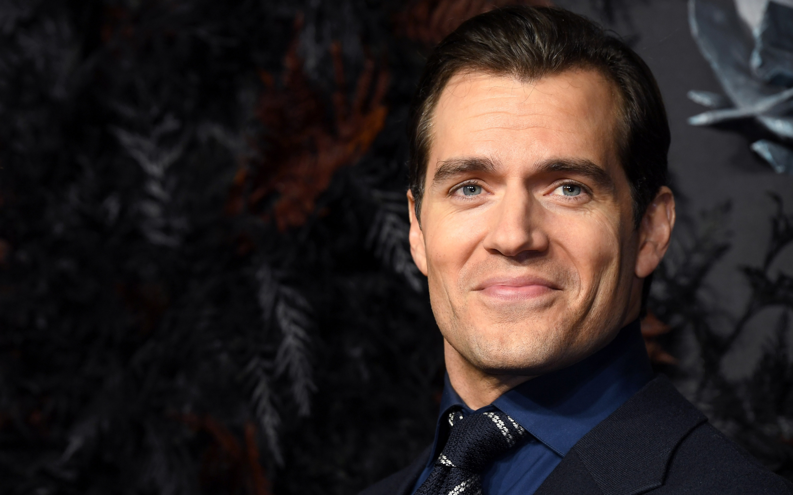 Улыбающийся актер Генри Кавилл в костюме