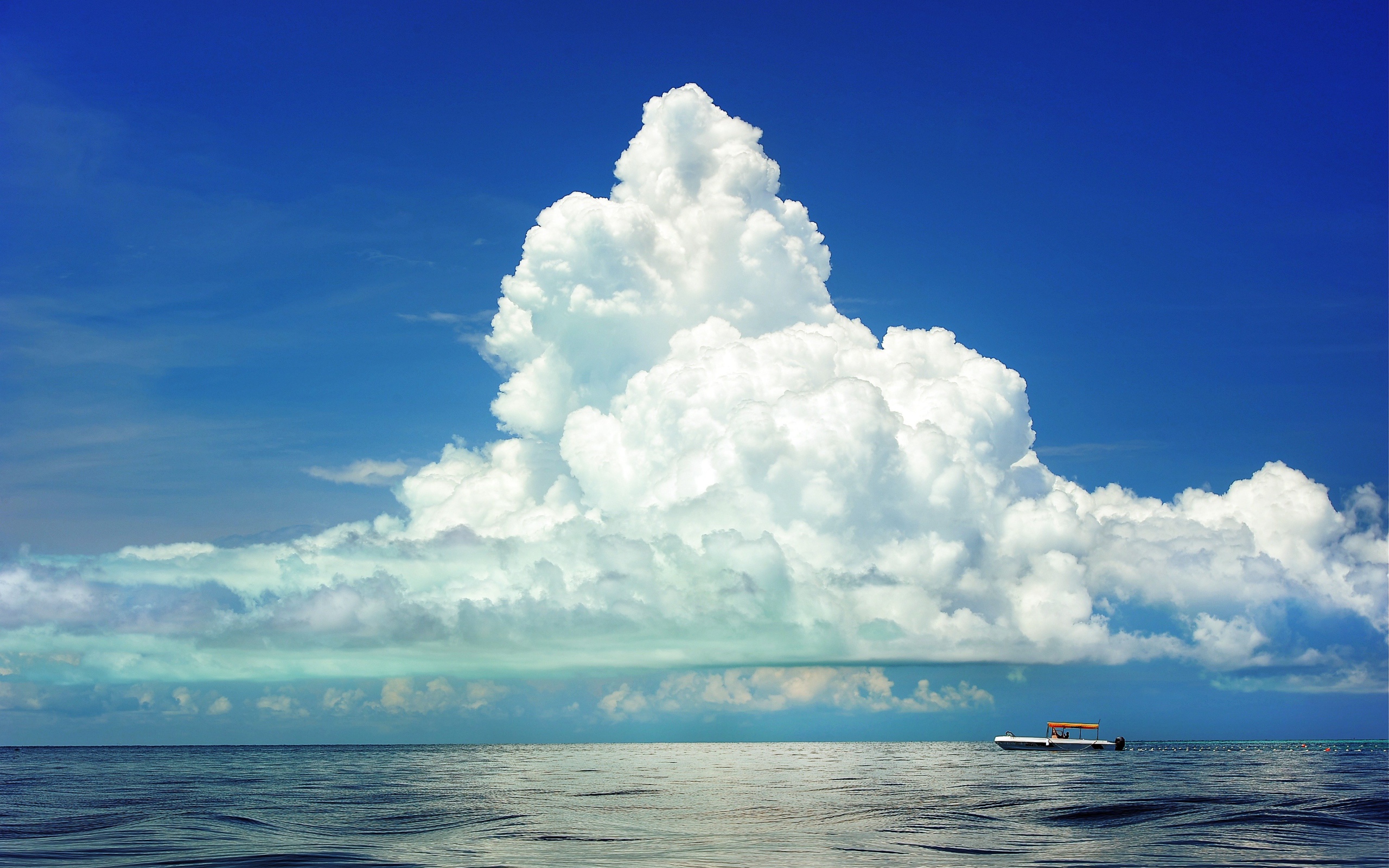 Large white cloud in the blue sky over the sea