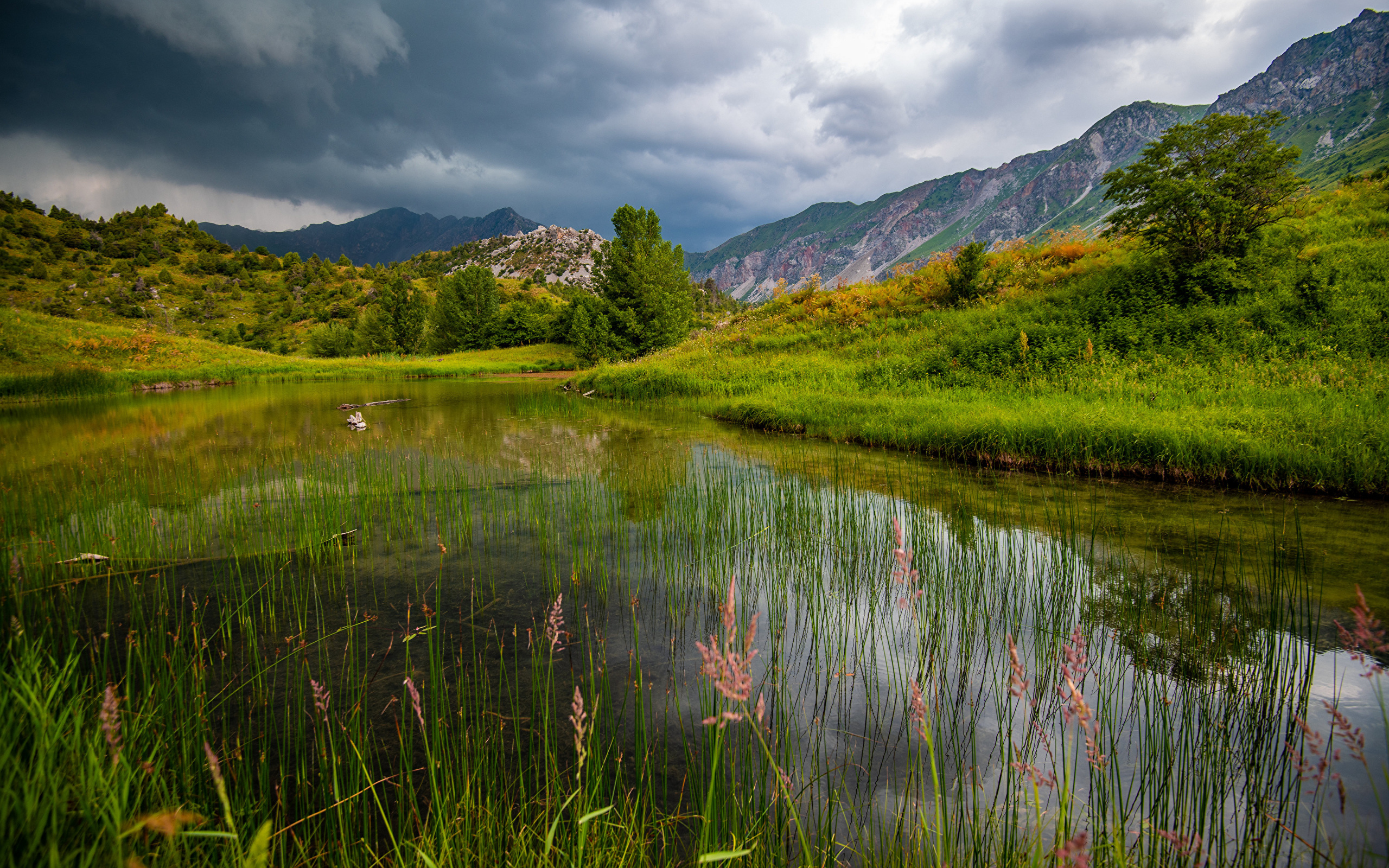 Грозовые облака над рекой в горах 