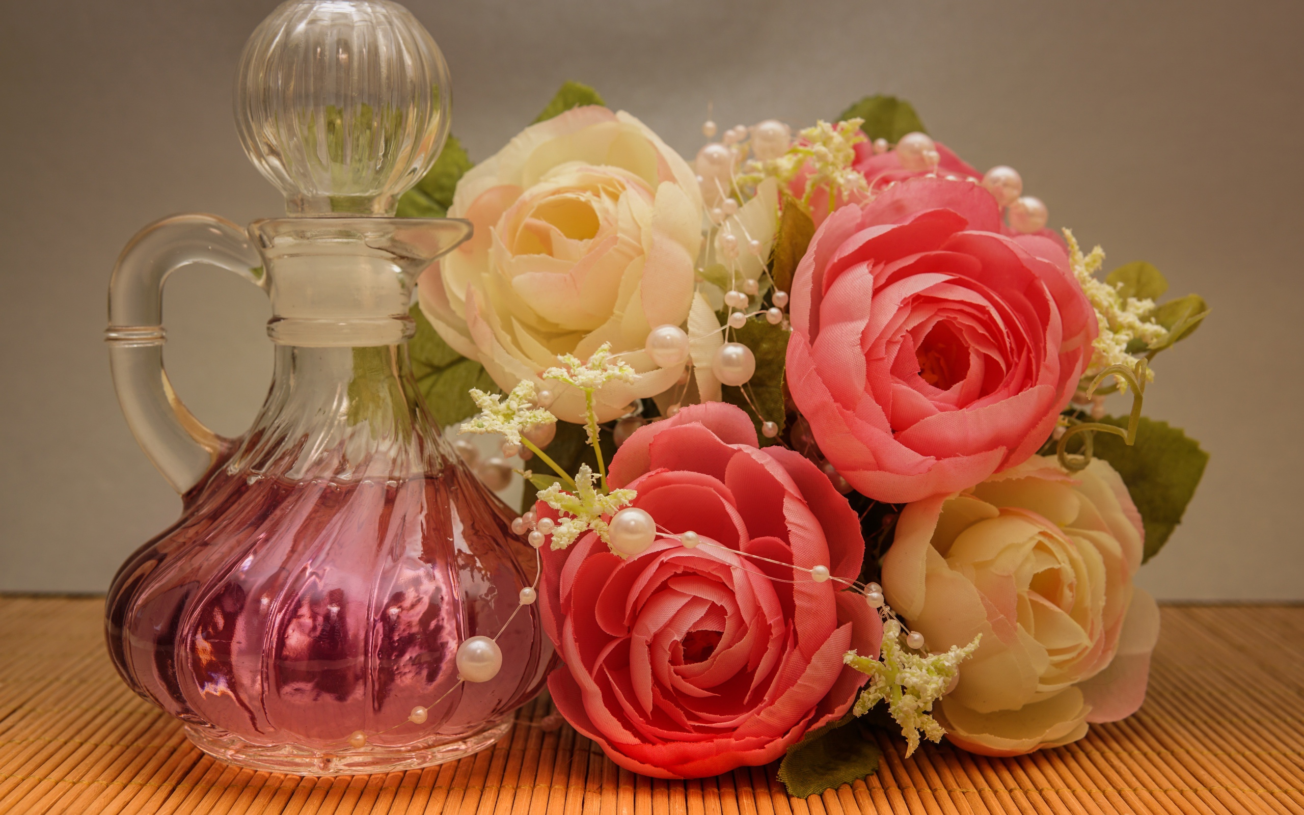 Красивый букет искусственных роз на столе с духами