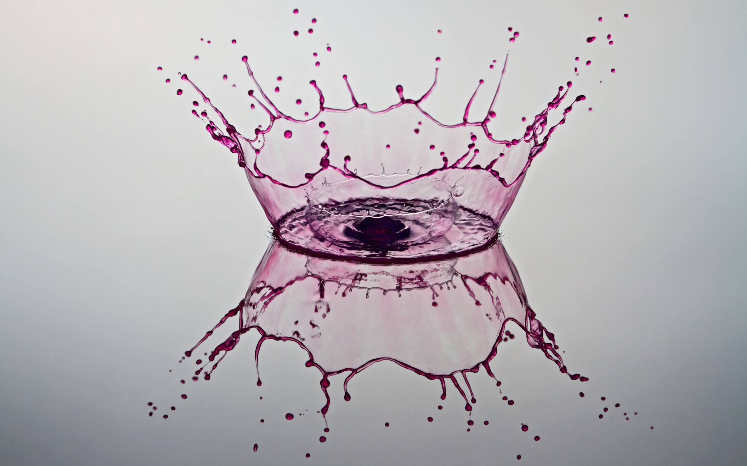 Брызги фиолетовой краски на сером фоне 