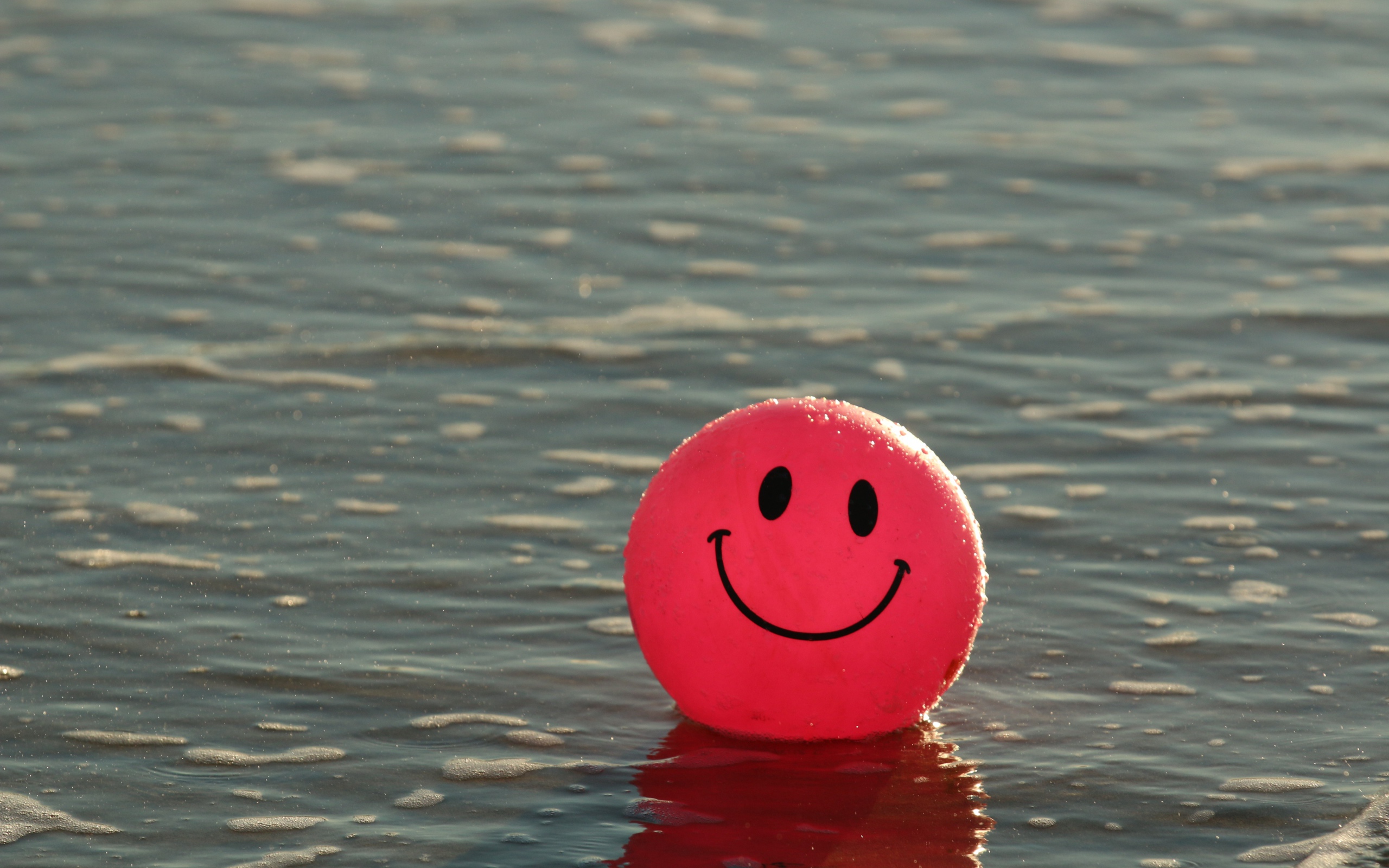 Красный мяч смайлик в воде 