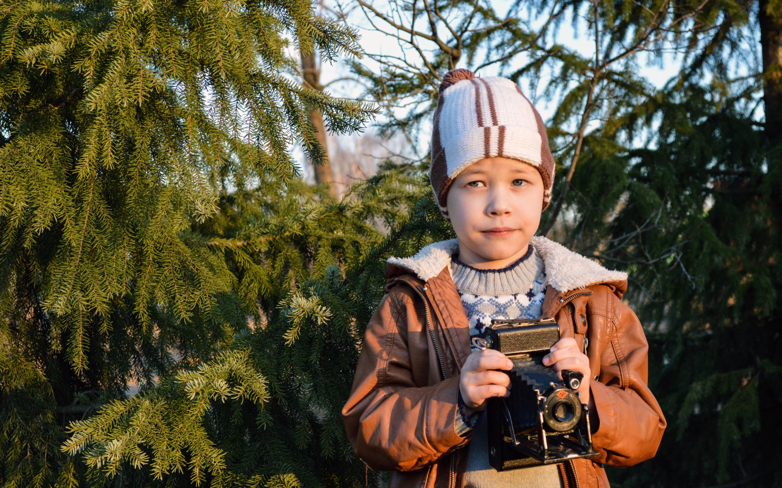 Мальчик с фотоаппаратом у ели