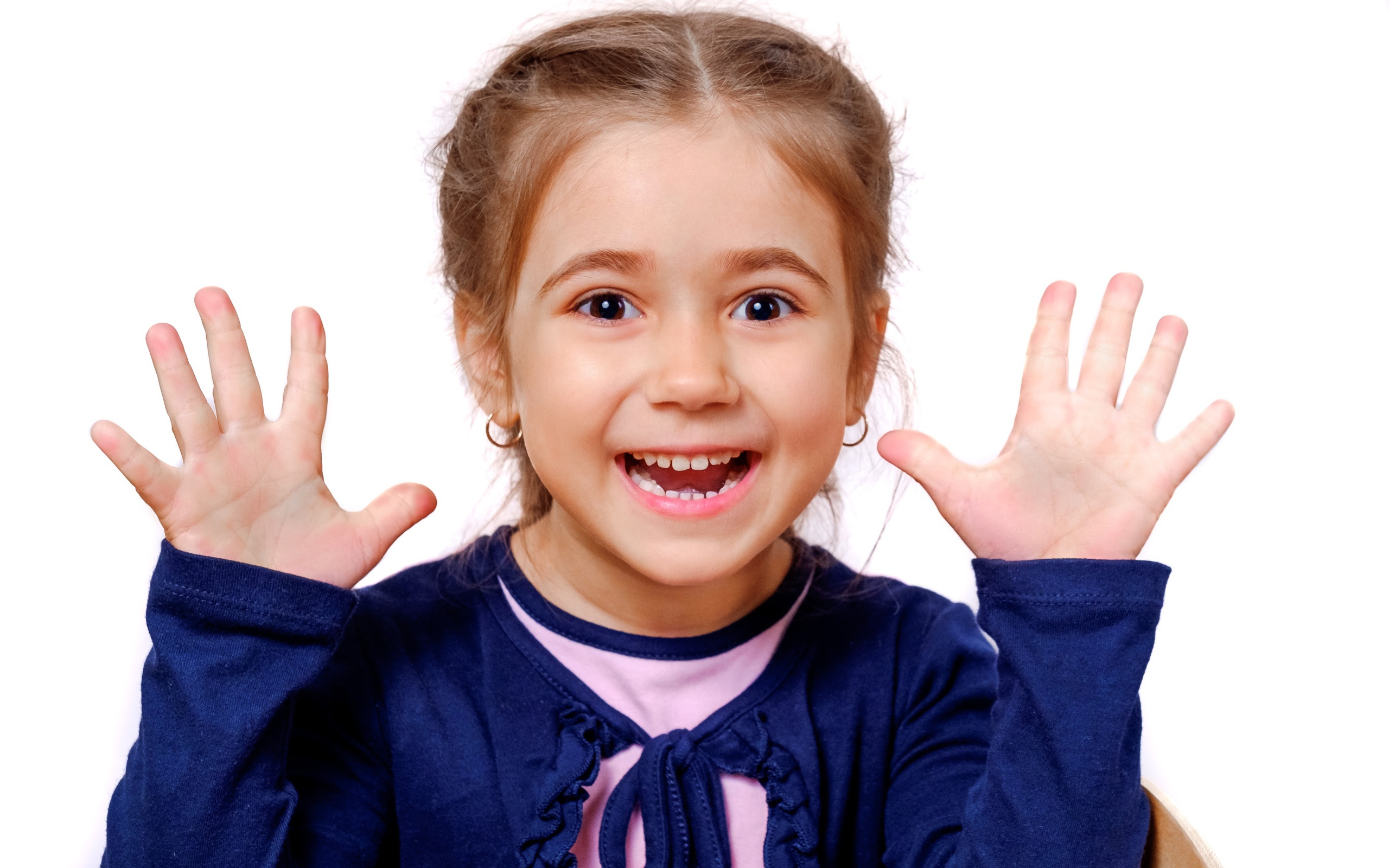 Веселая маленькая девочка с поднятыми руками