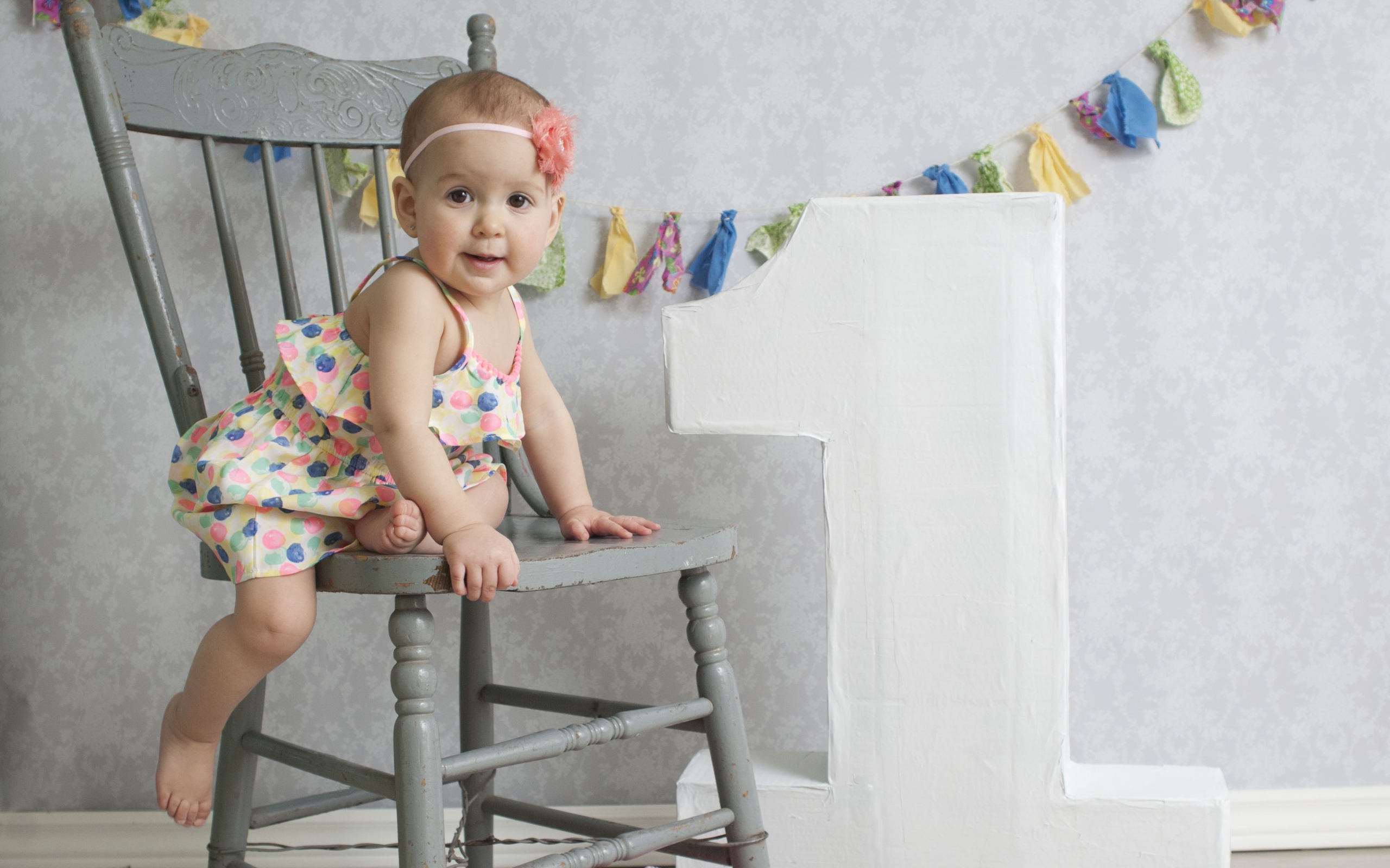 Маленькая девочка в платье на стуле