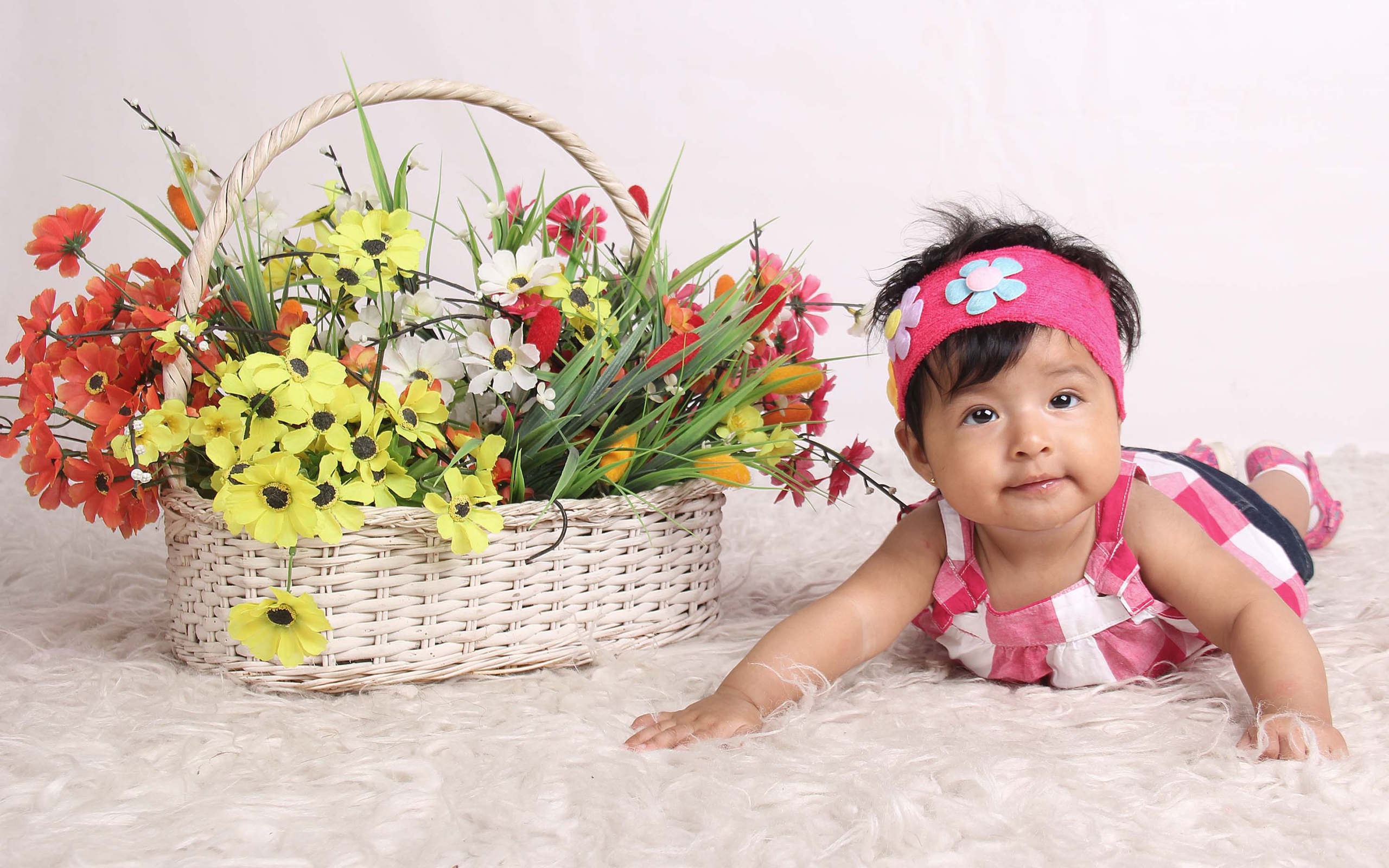 Маленькая девочка рядом с корзиной цветов 