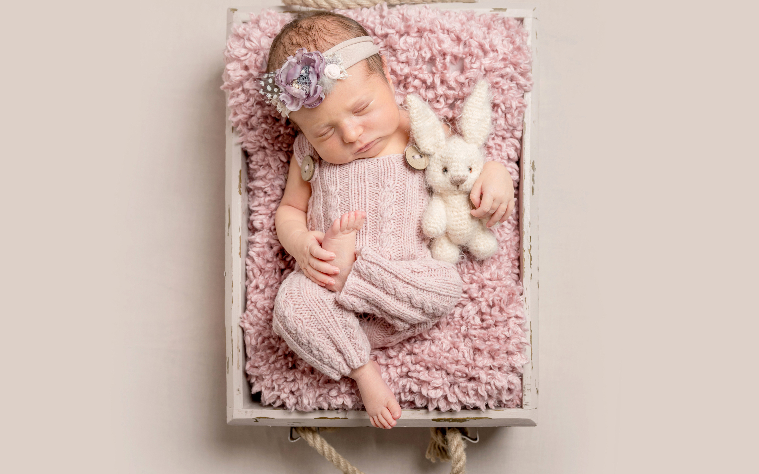 Маленькая новорожденная девочка спит в ящике 