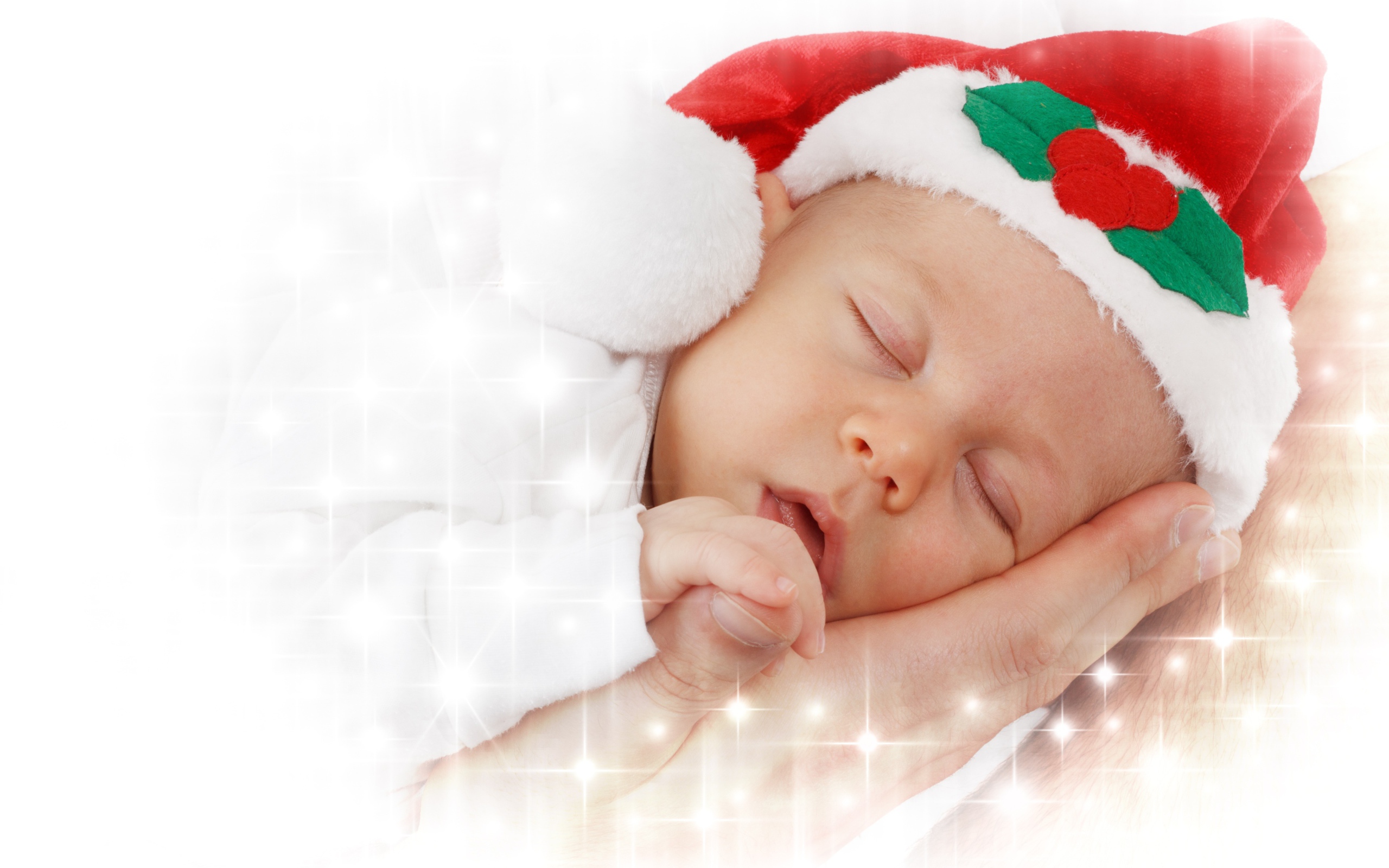 Маленький спящий ребенок в новогодней шапке 