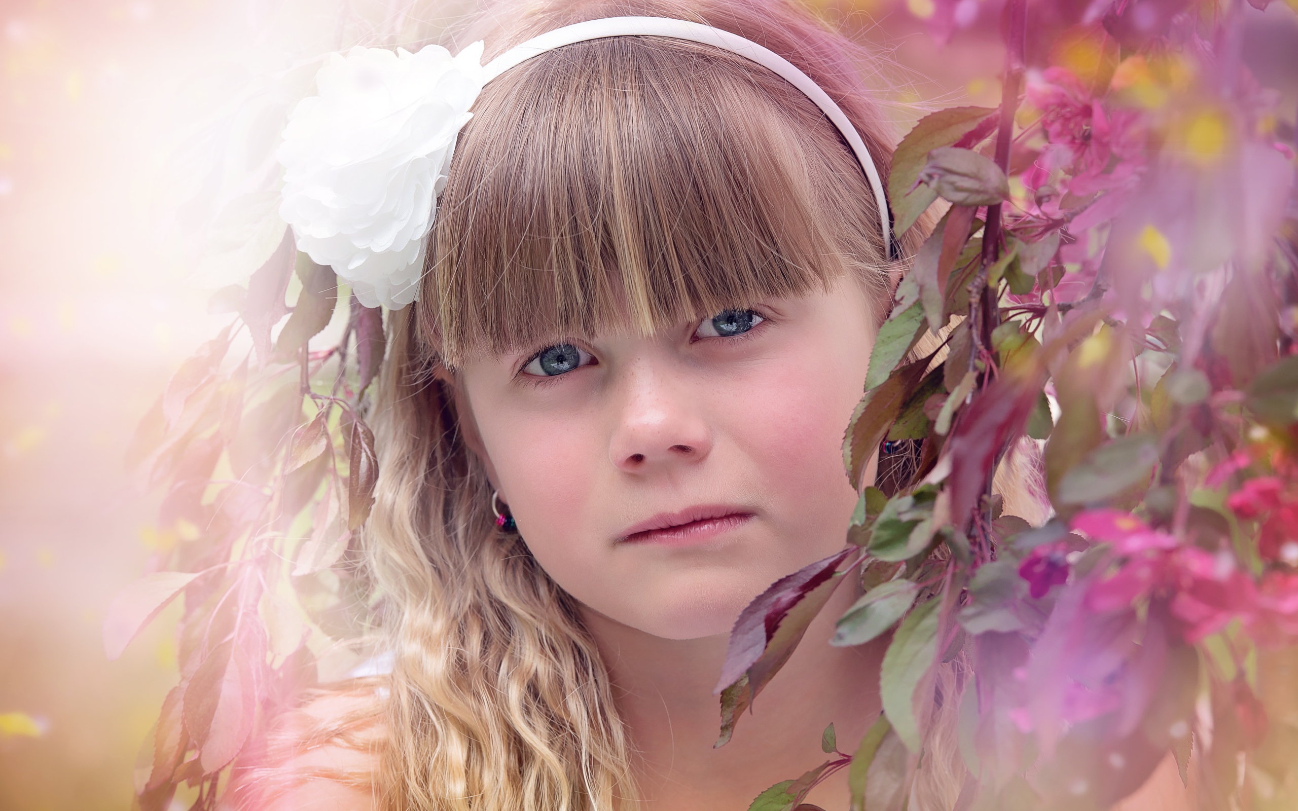 Грустная маленькая девочка у ветки дерева 