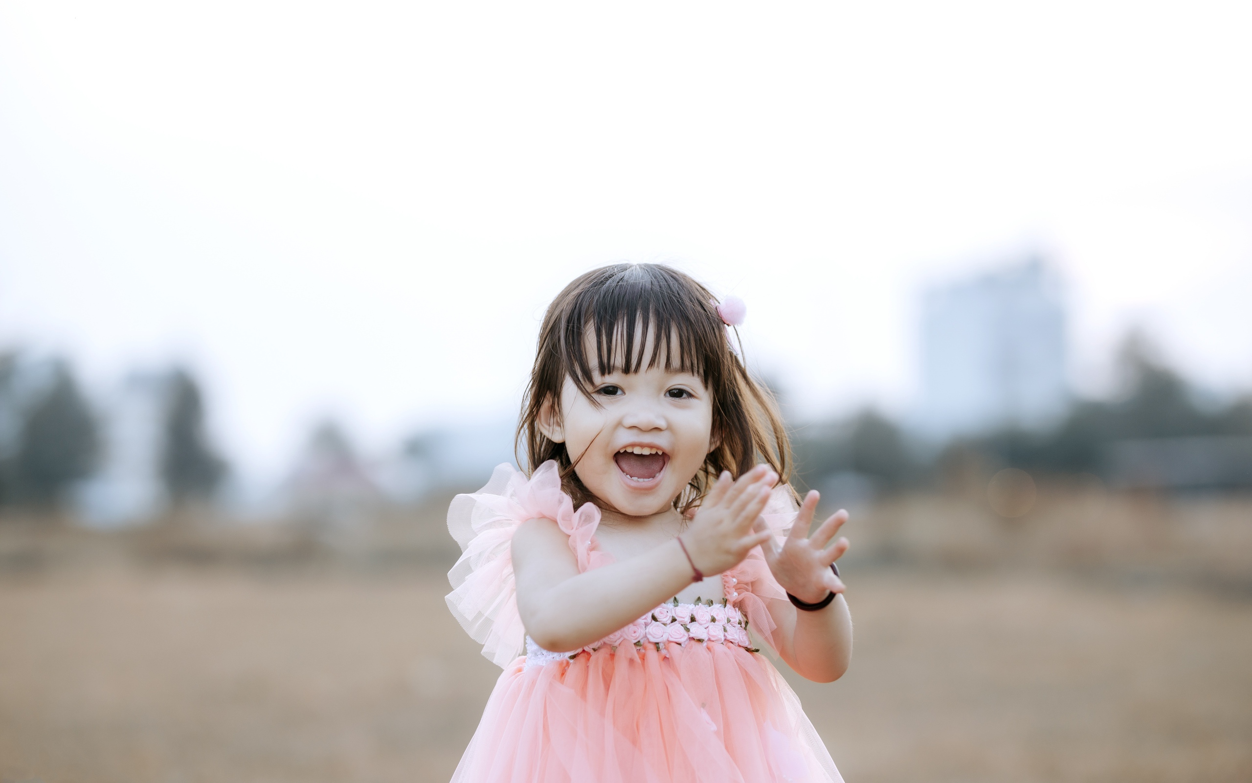 Довольная маленькая девочка в розовом платье 