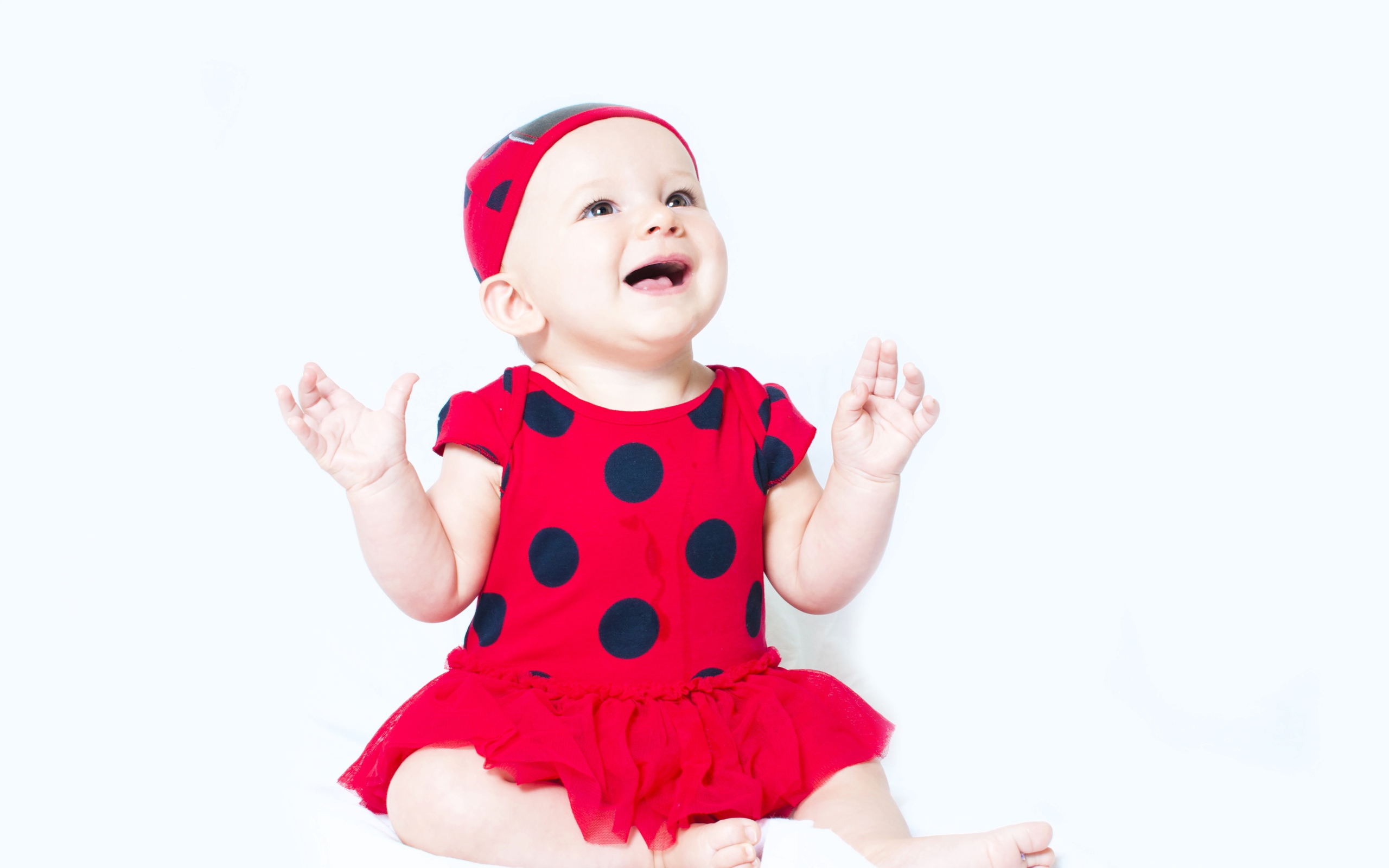 Улыбающаяся девочка в красном платье с черными кругами