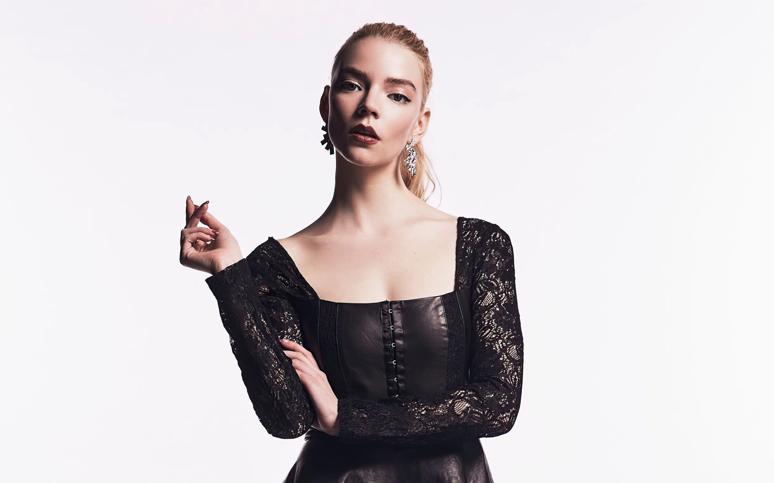 Актриса Аня Тейлор-Джой в черном наряде на белом фоне