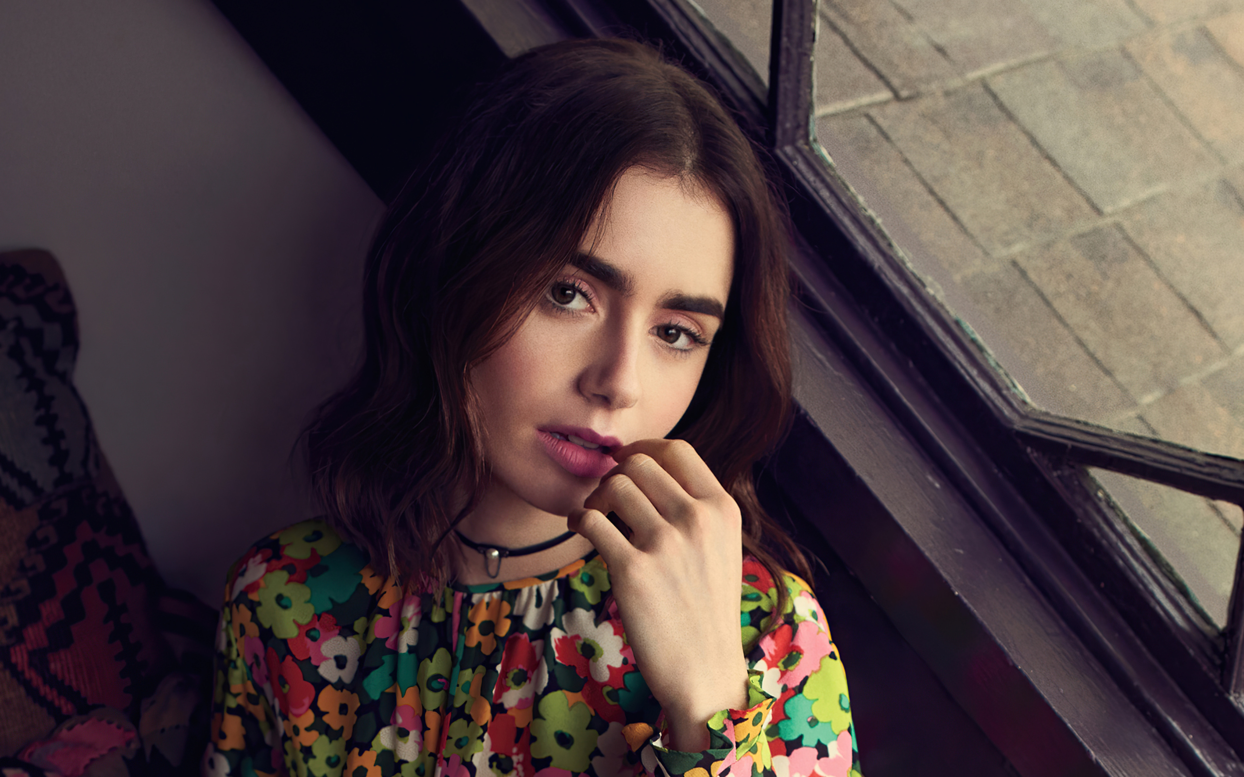 Актриса Лили Коллинз сидит у окна