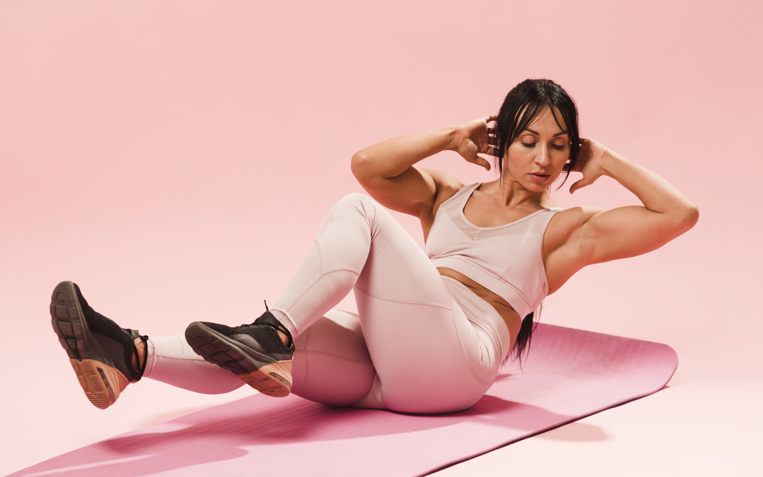 Спортивная девушка качает пресс на коврике