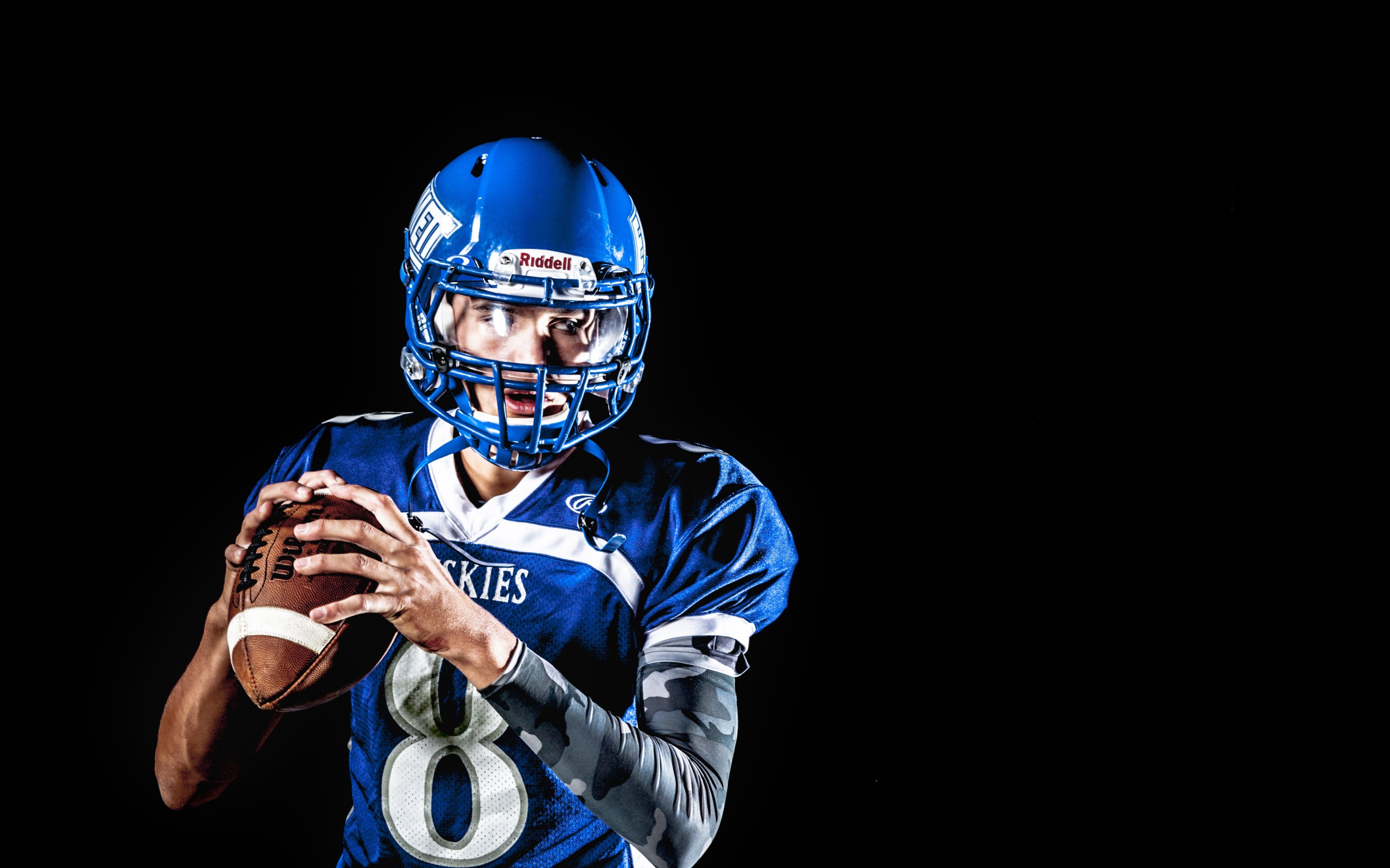 Мужчина игрок в американский футбол на черном фоне