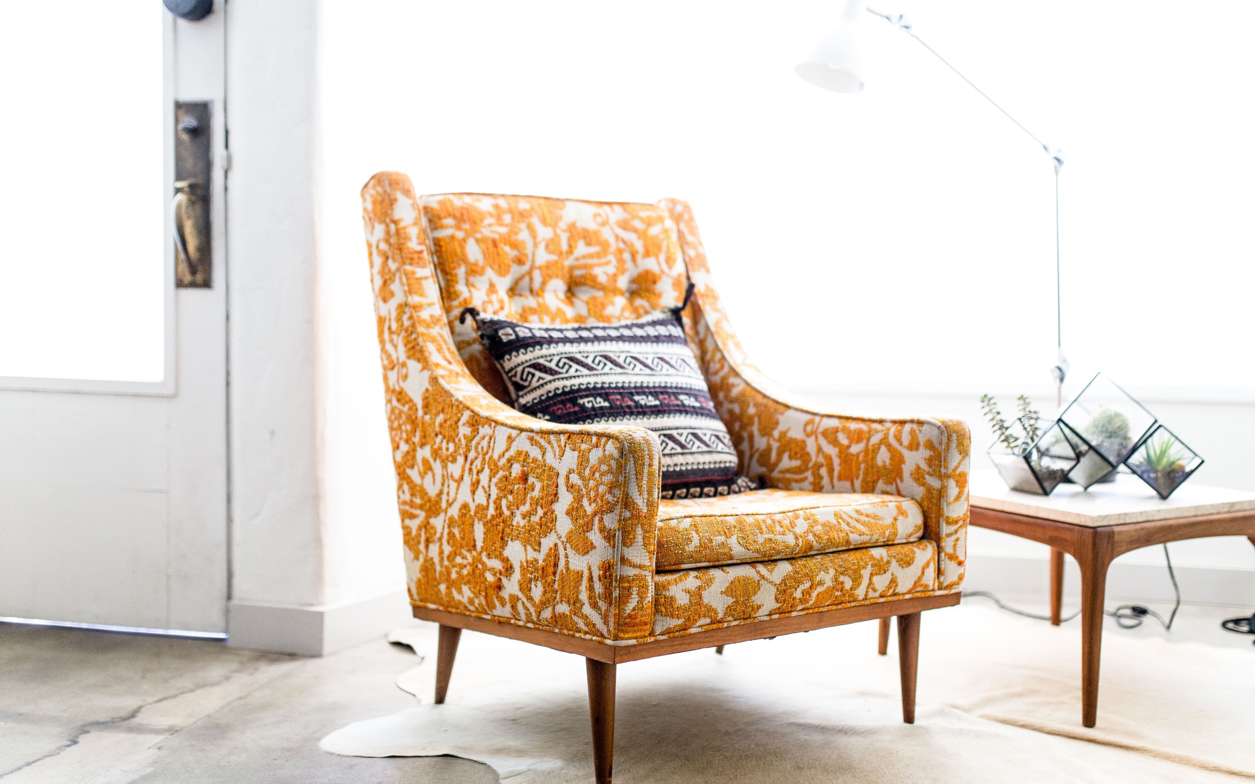 Старое кресло с подушкой в комнате 