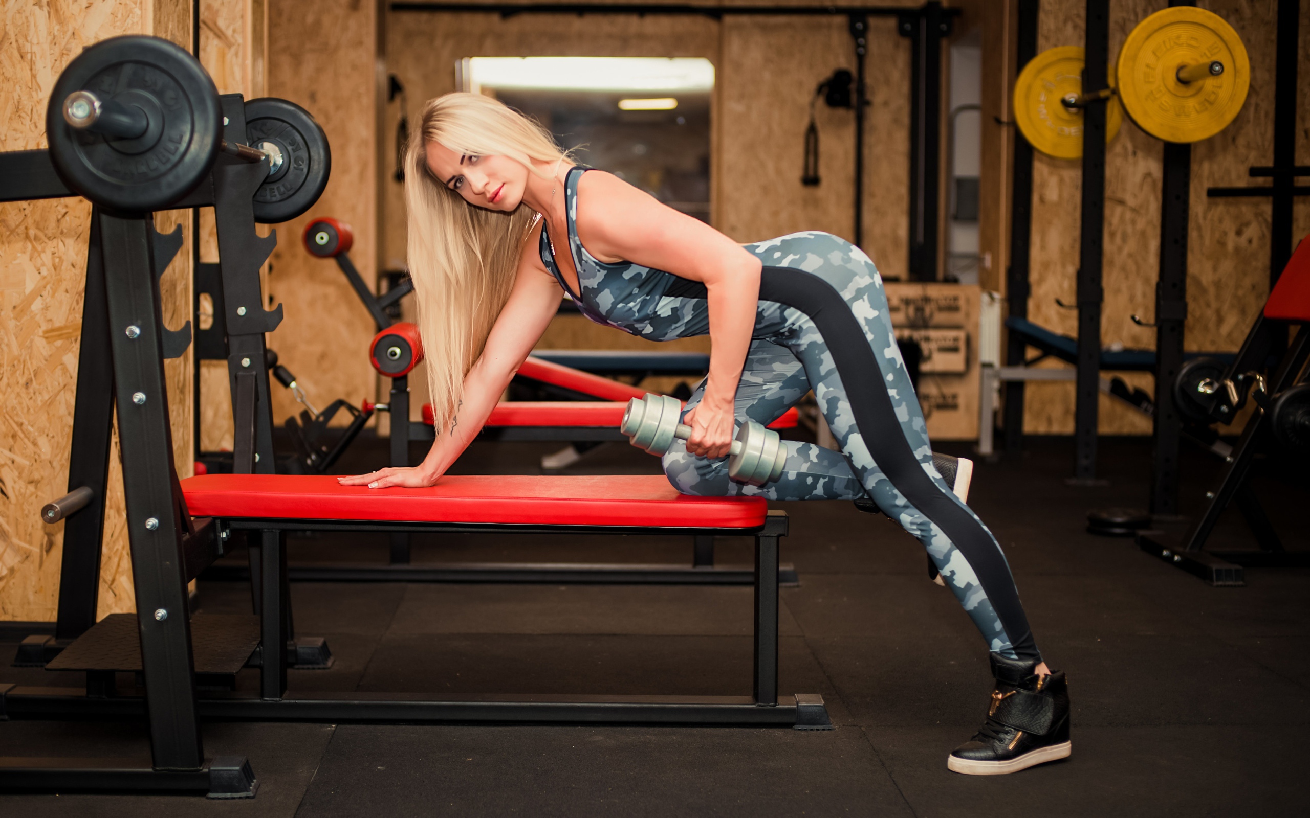 Стройная спортивная девушка с гантелей