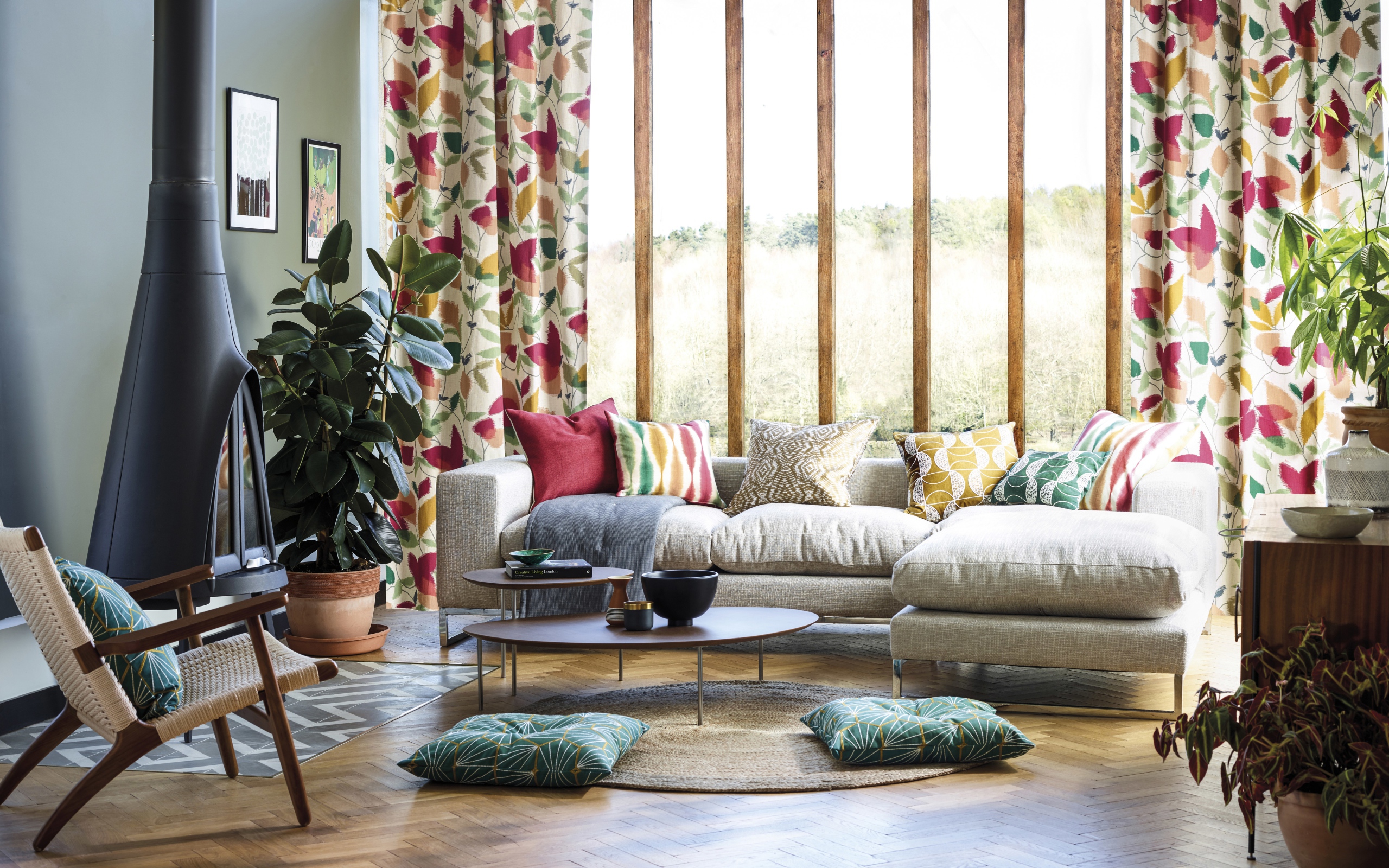 Белый диван с подушками стоит у окна