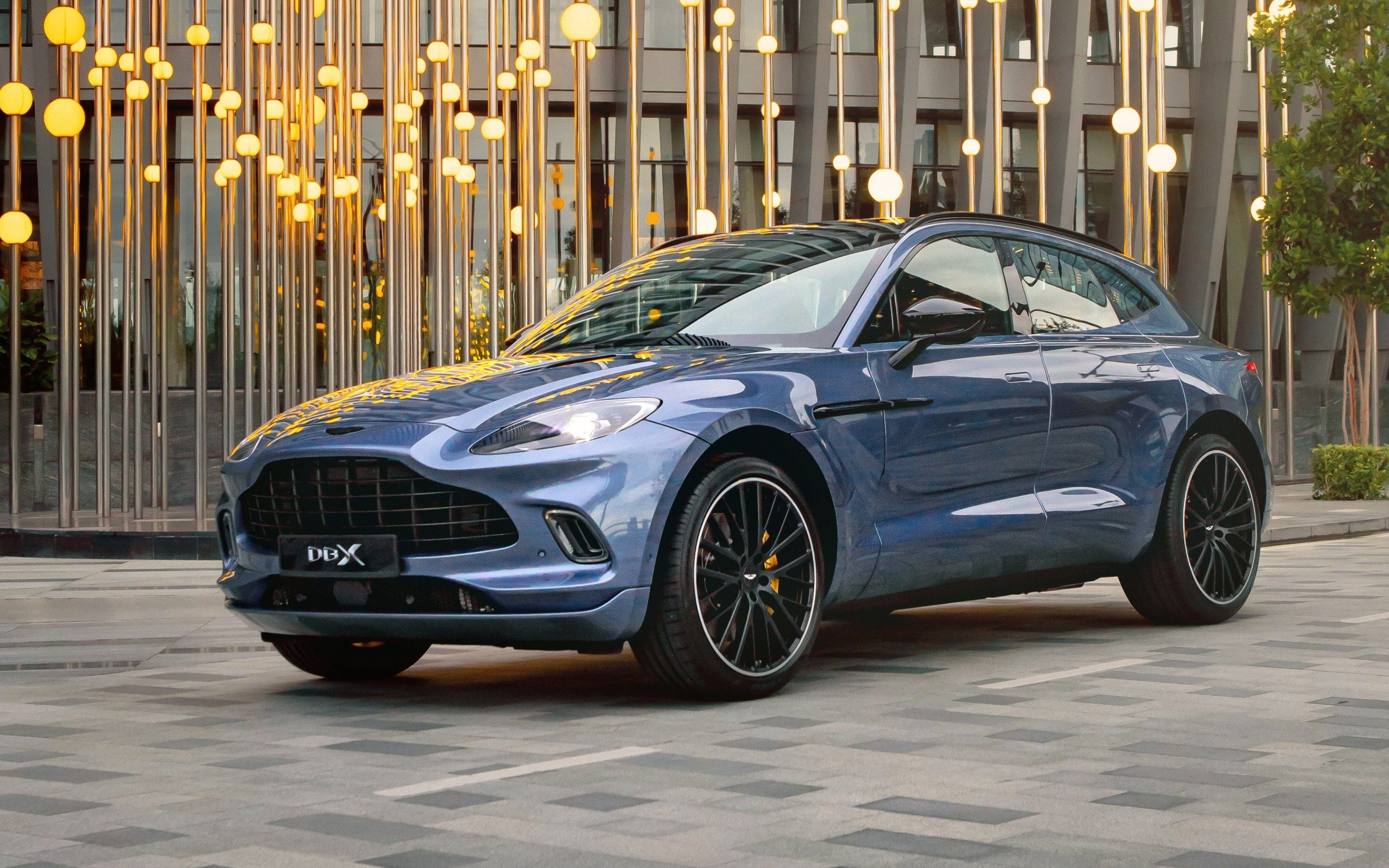 Автомобиль Aston Martin DBX у здания