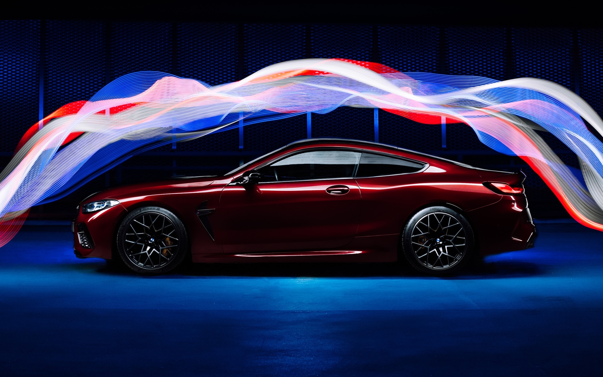 Бордовый автомобиль BMW M8 Competition оптекает волнами