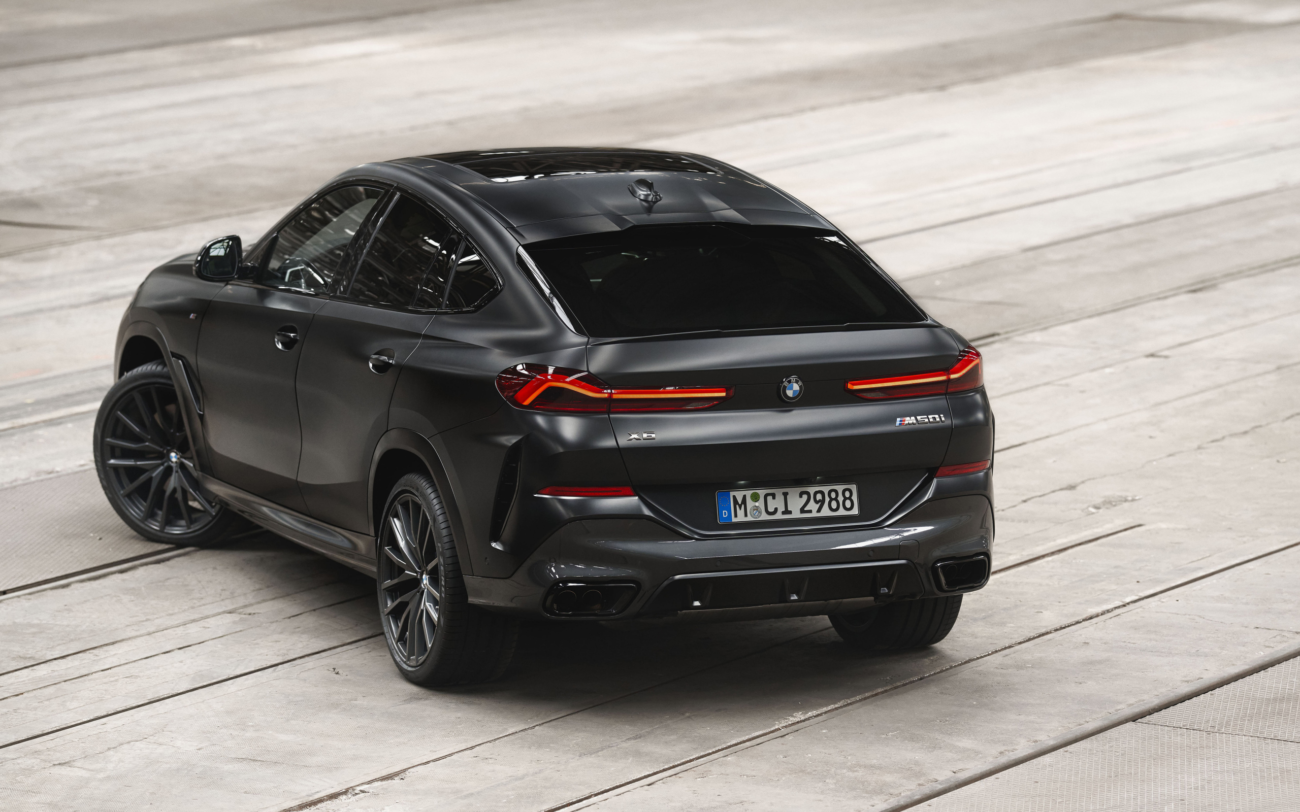 Стильный черный автомобиль BMW X6 M50i, 2023 года вид сзади