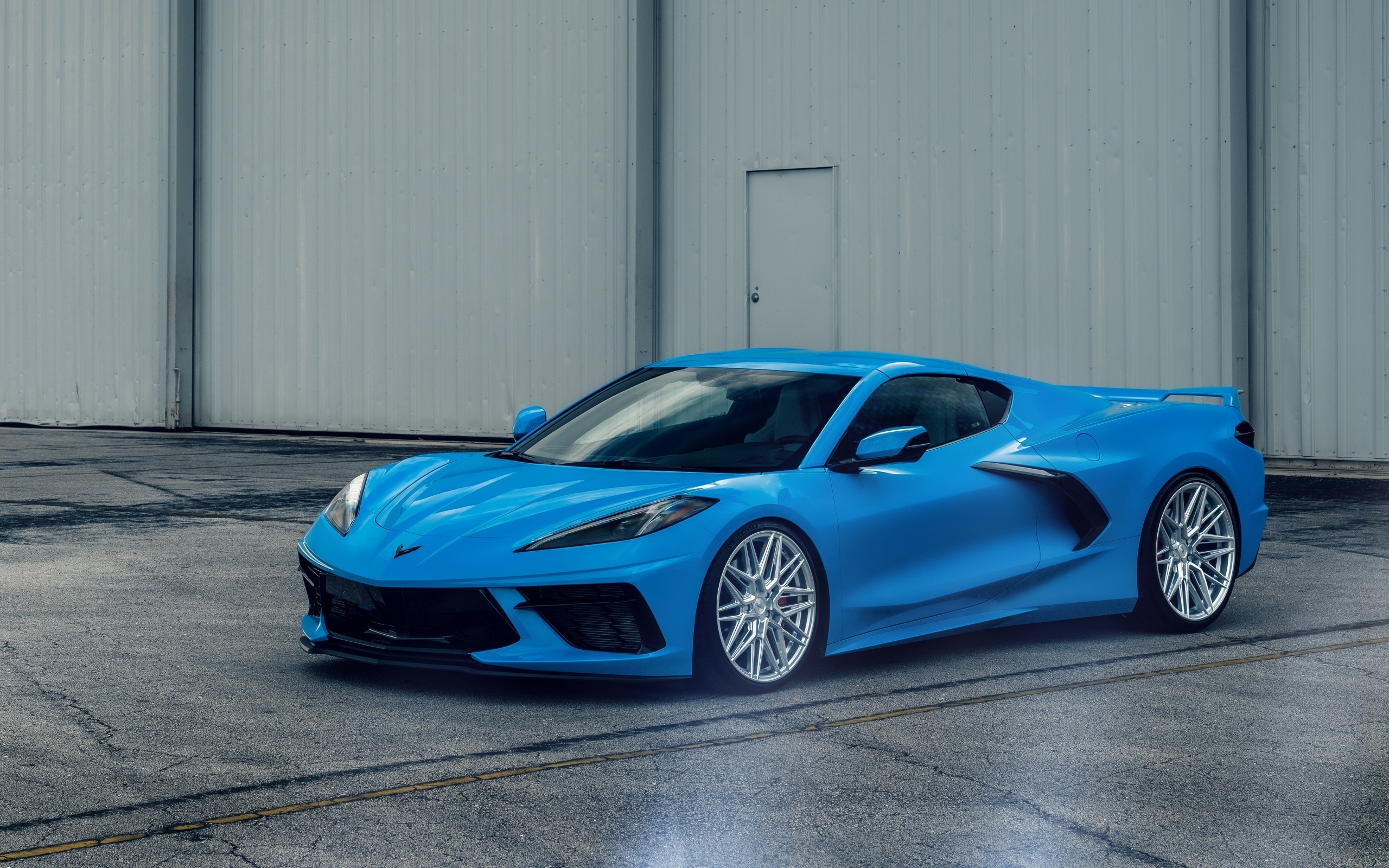 Синий Chevrolet Corvette C8 у серого здания