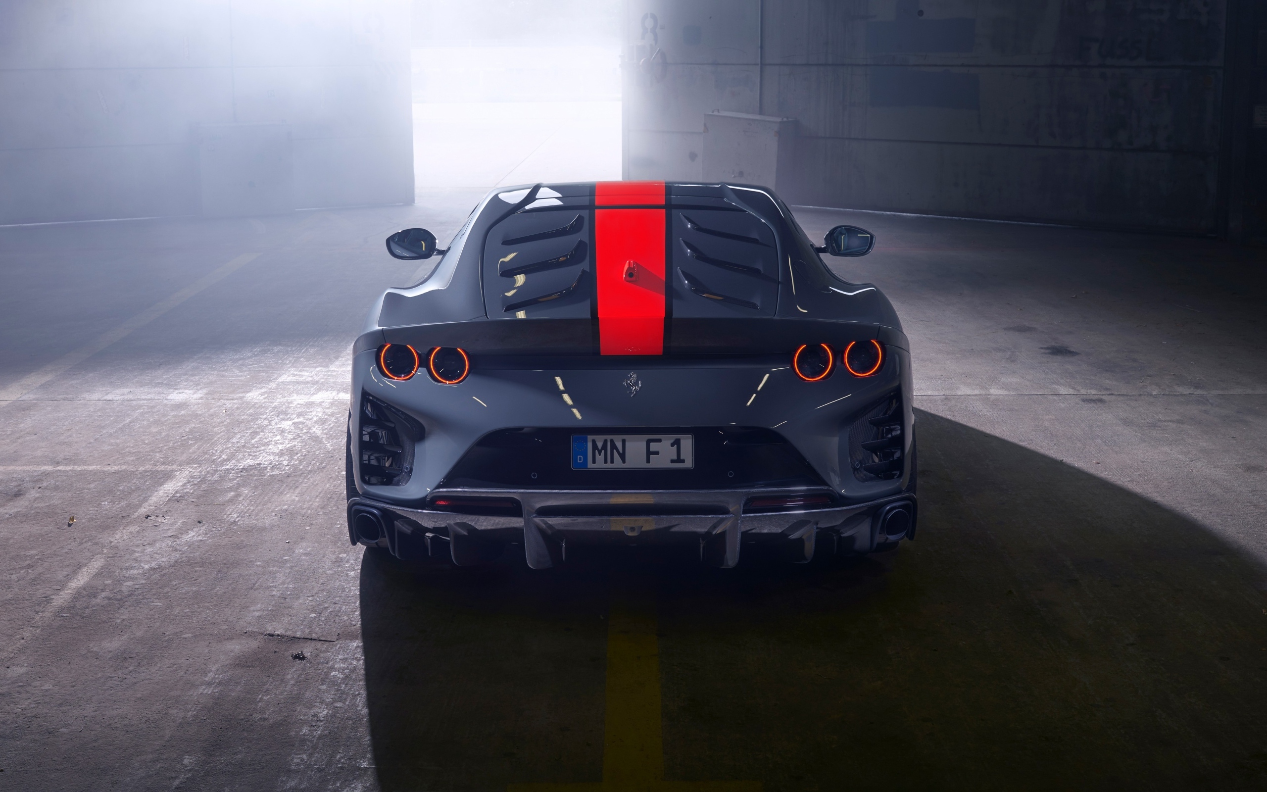 Серый спортивный автомобиль Ferrari 812 вид сзади