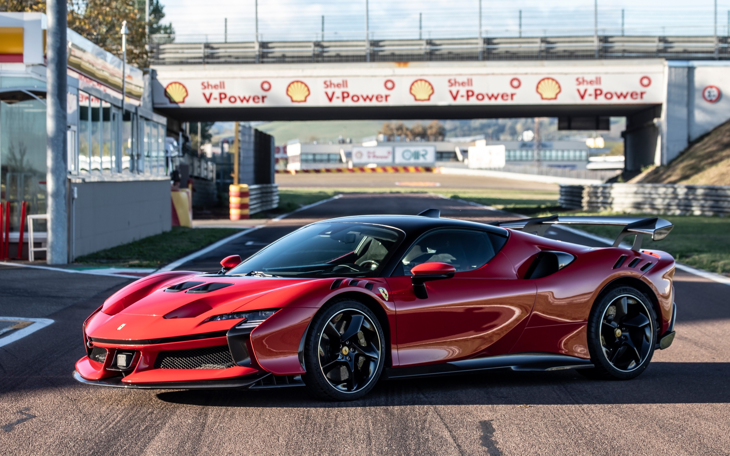 Красный автомобиль Ferrari SF90 XX Stradale на стадионе