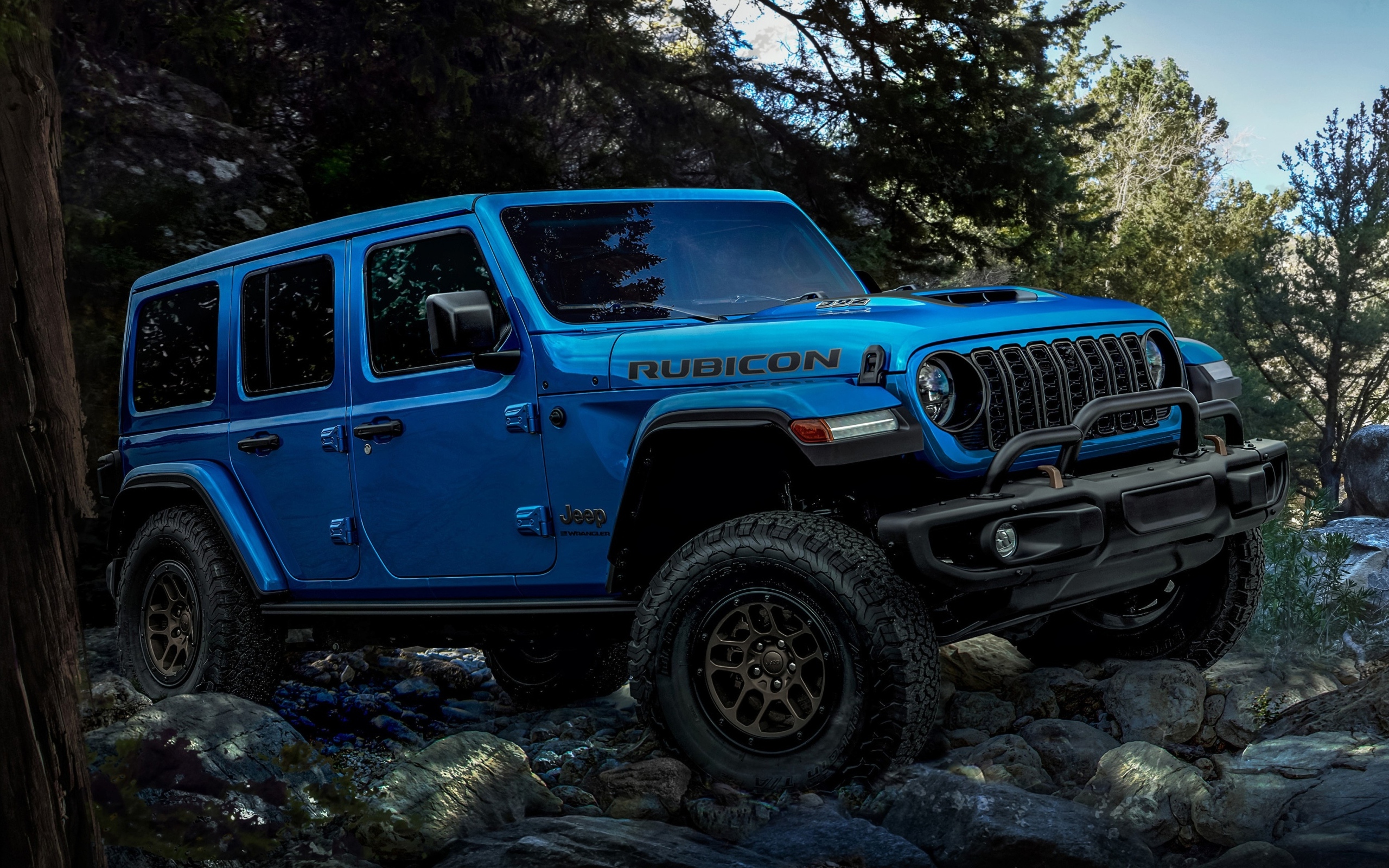 Синий Jeep Wrangler Unlimited Rubicon 2023 года на бездорожье