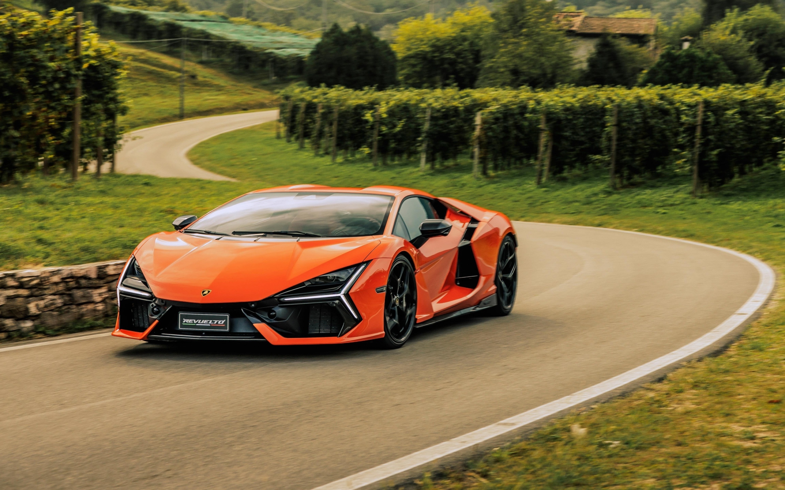 Оранжевый автомобиль Lamborghini Revuelto на дороге