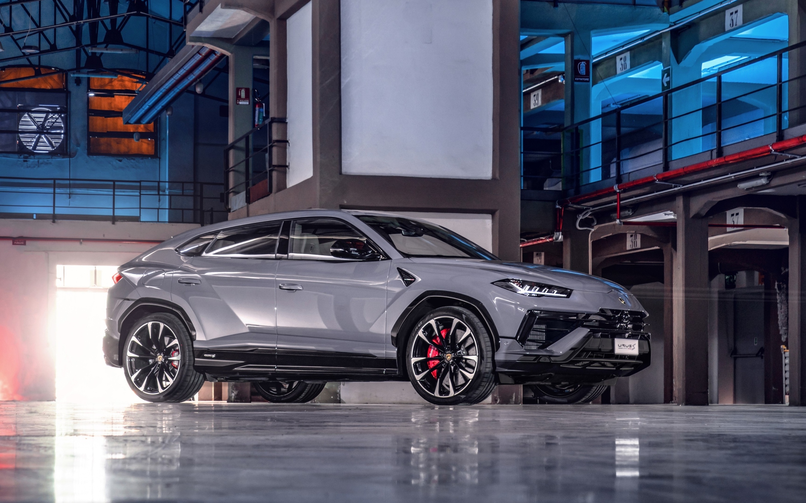 Серебристый автомобиль Lamborghini Urus S в здании