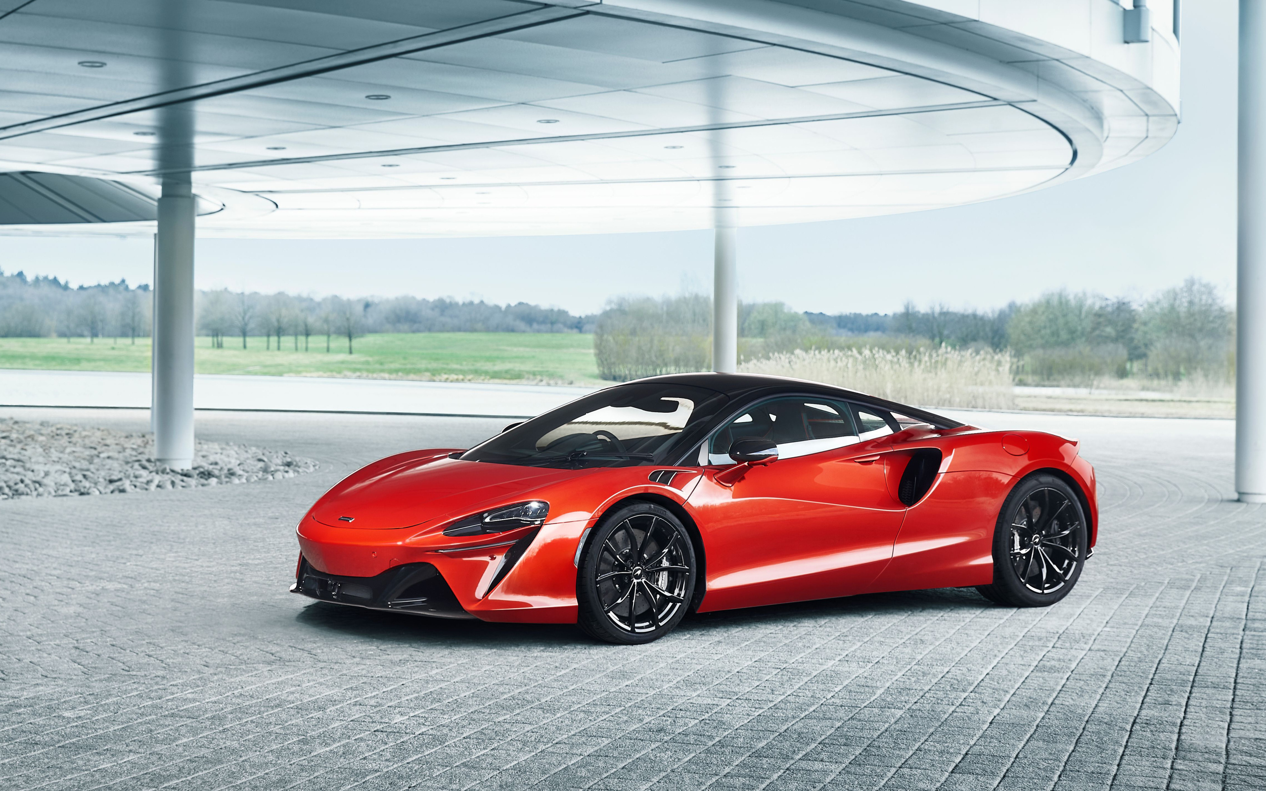 Спортивный красный автомобиль McLaren Artura 2023 года