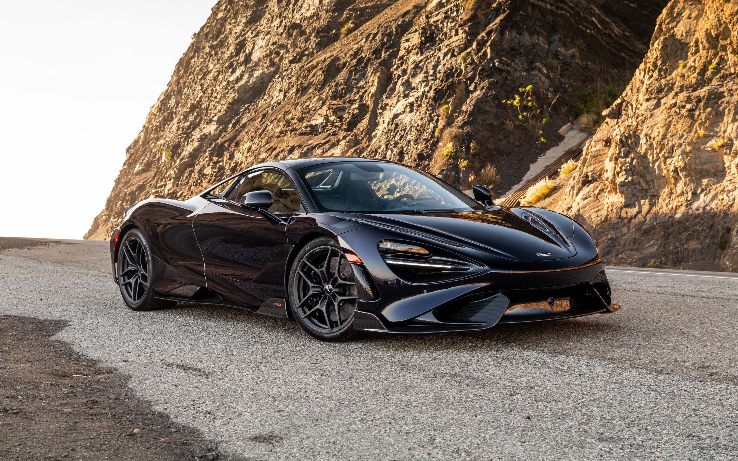 Черный спортивный автомобиль McLaren 765LT Spider у гор