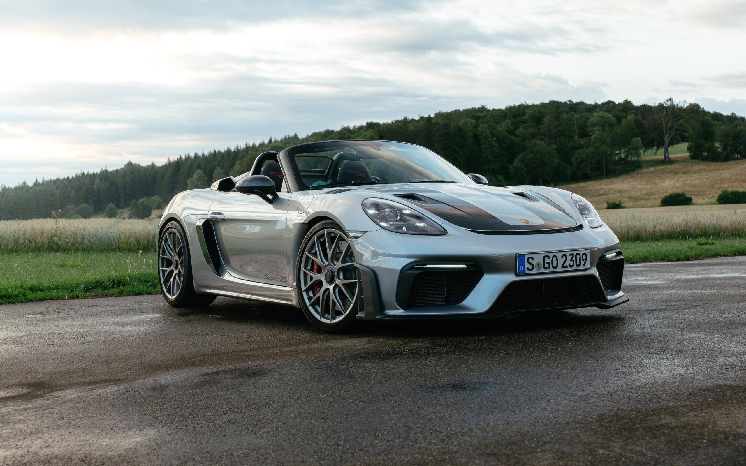 Быстрый Porsche 718 Spyder RS на мокрой дороге