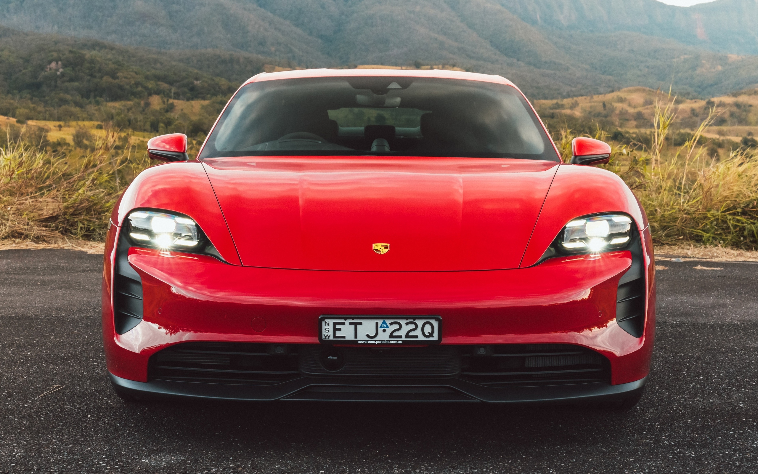 Красный автомобиль Porsche Taycan GTS вид спереди