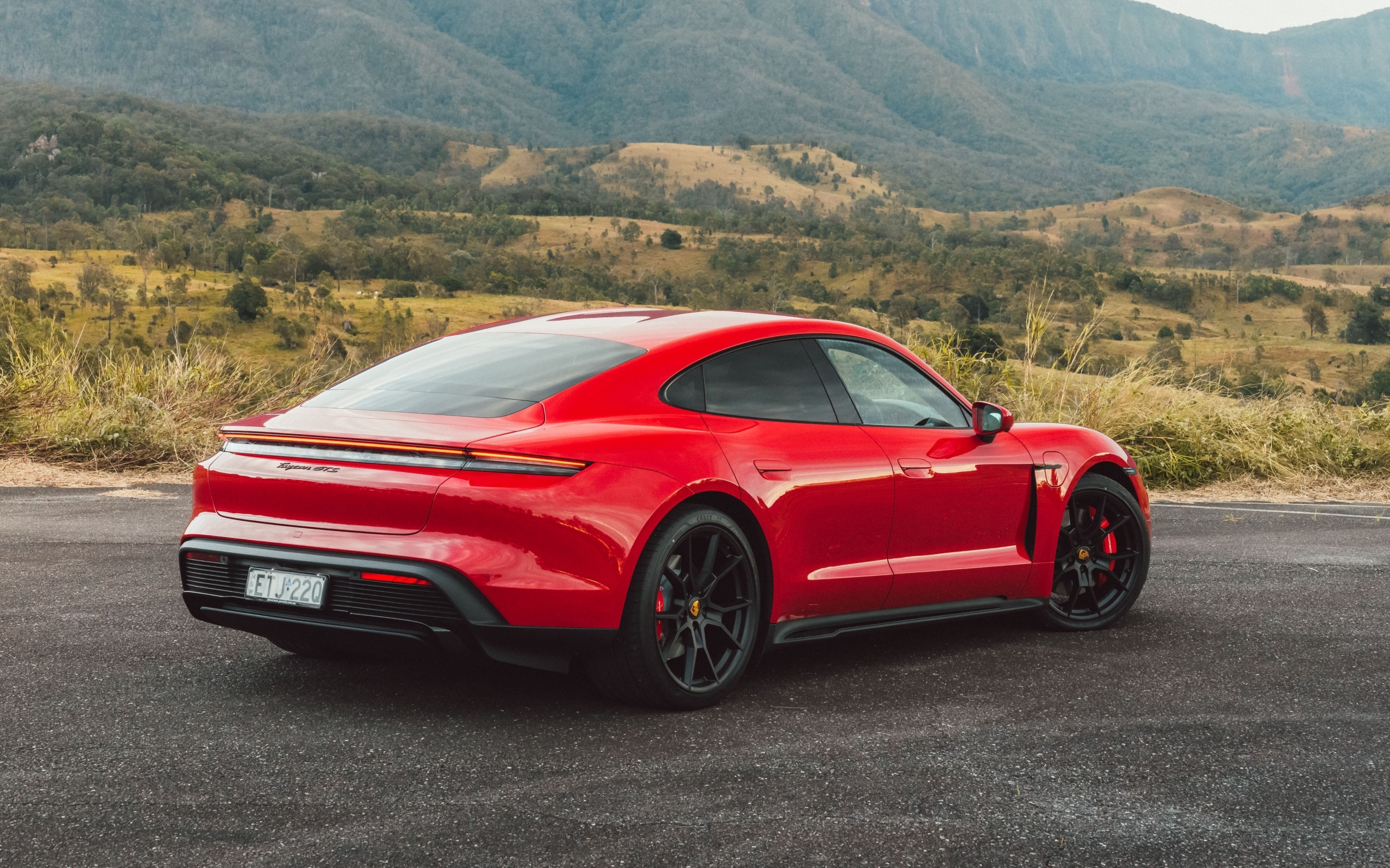 Красный автомобиль Porsche Taycan GTS вид сзади