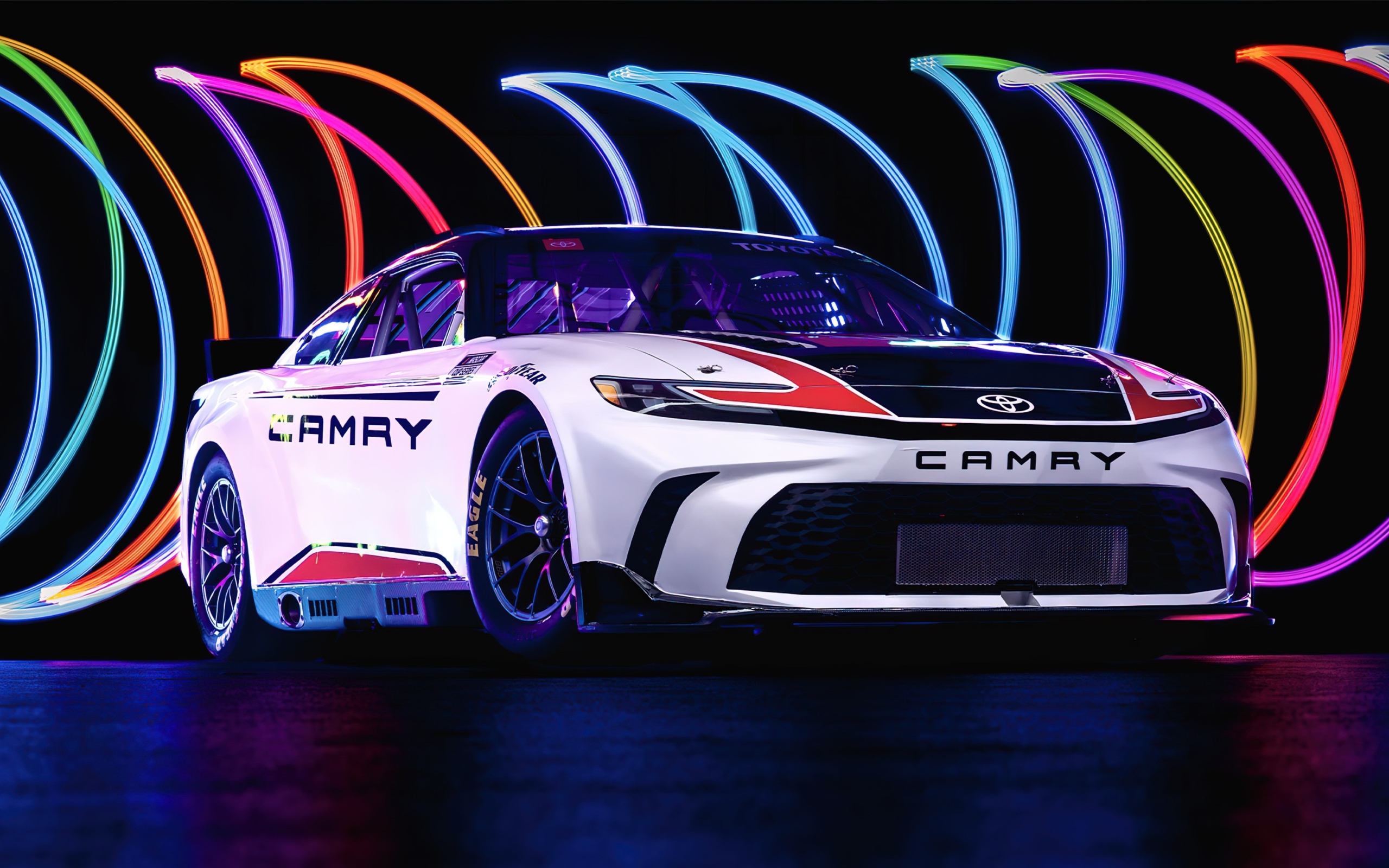 Автомобиль Toyota Camry XSE NASCAR Race Car 2024  года на разноцветном фоне