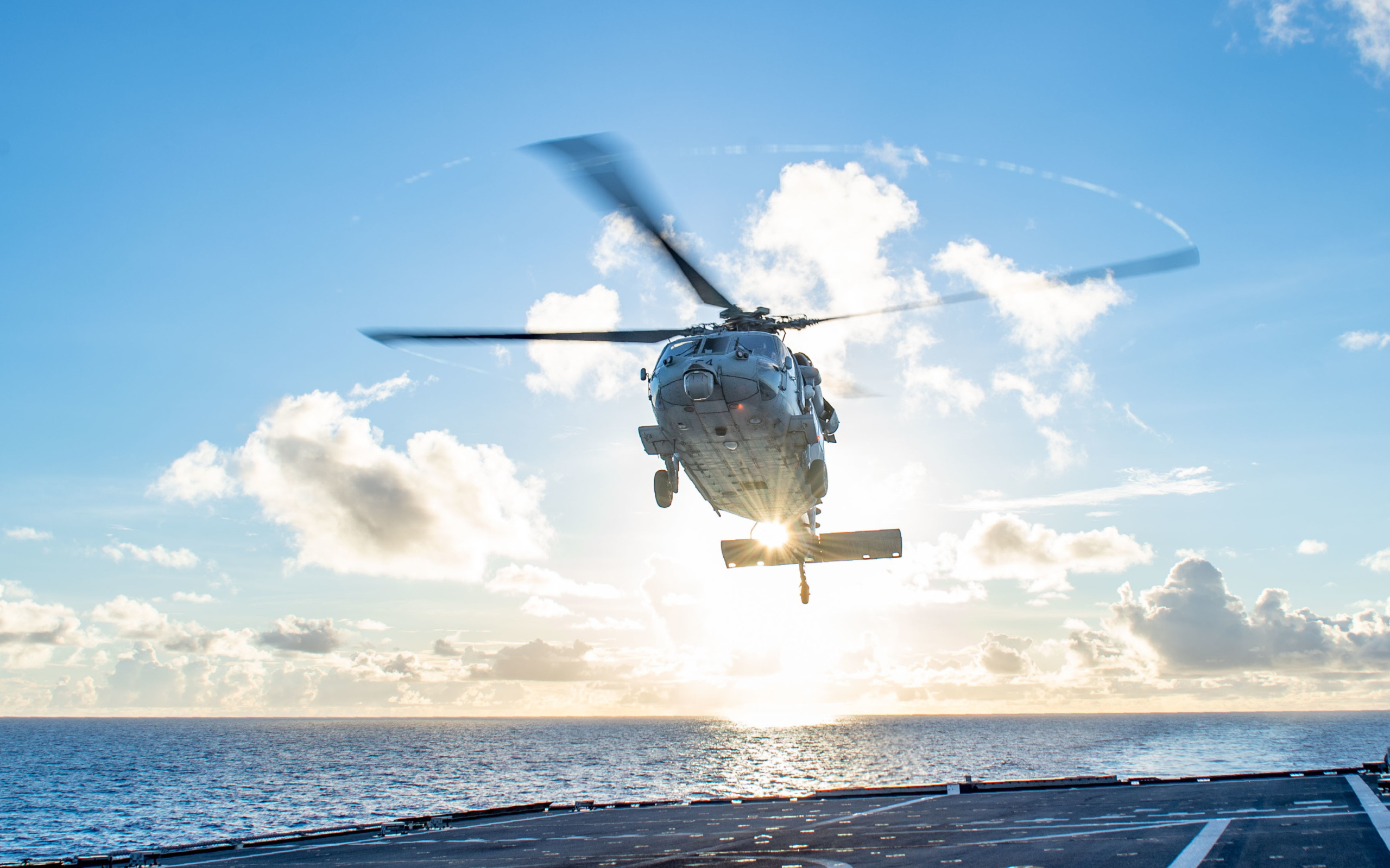 Военный вертолет приземляется на корабль в море