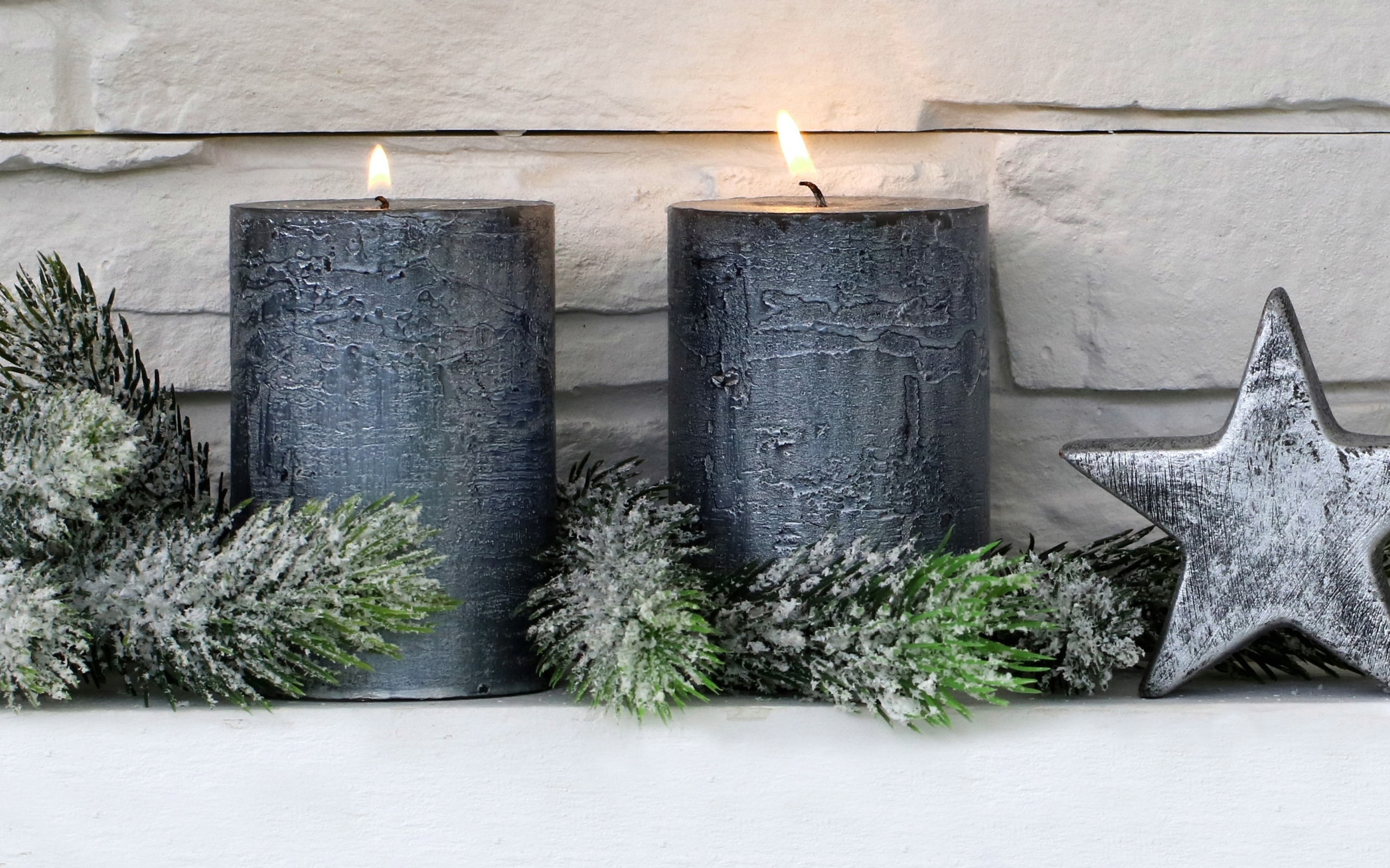 Две большие зажженные свечи у стены