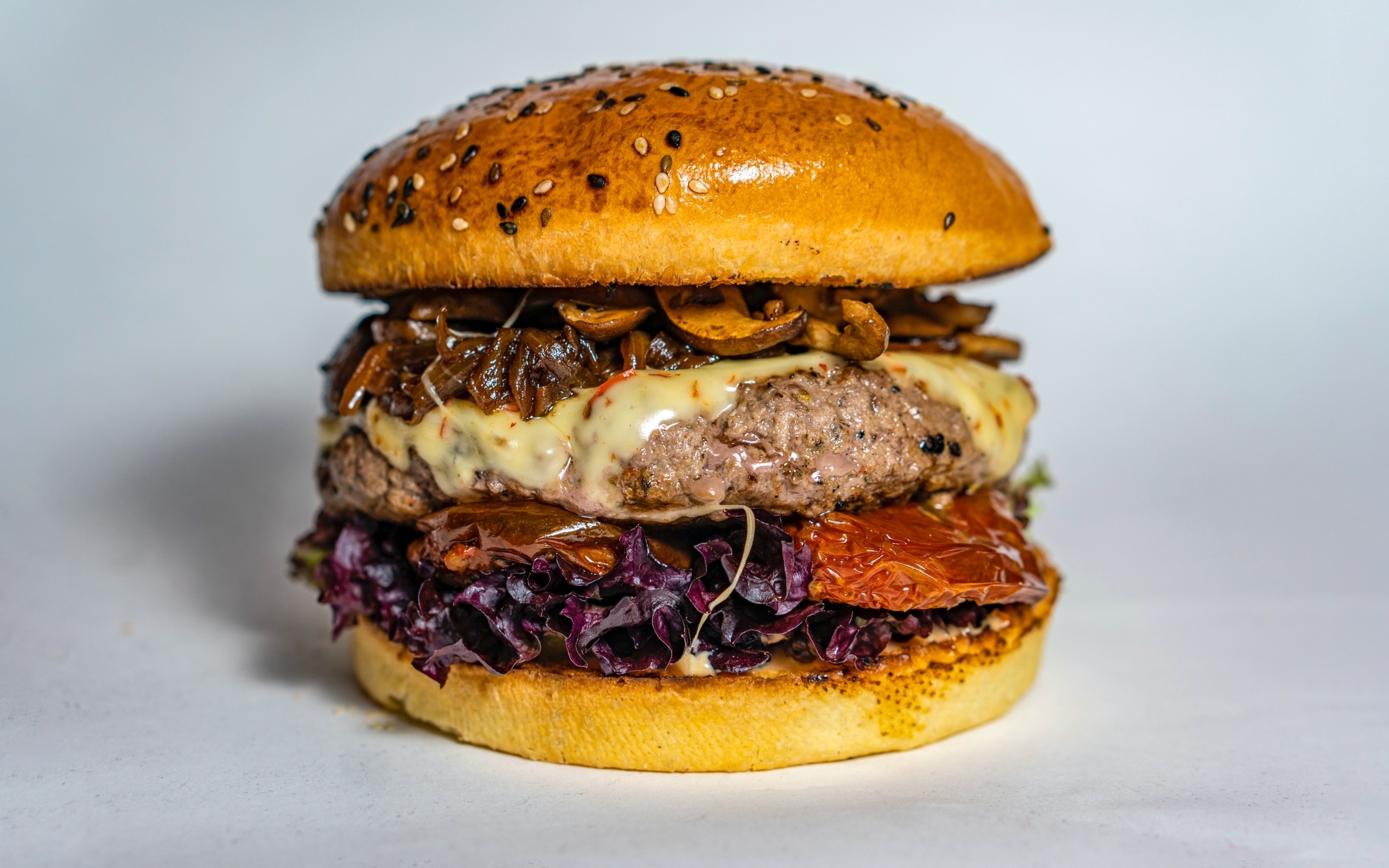 Ароматный сочный гамбургер на сером фоне крупным планом