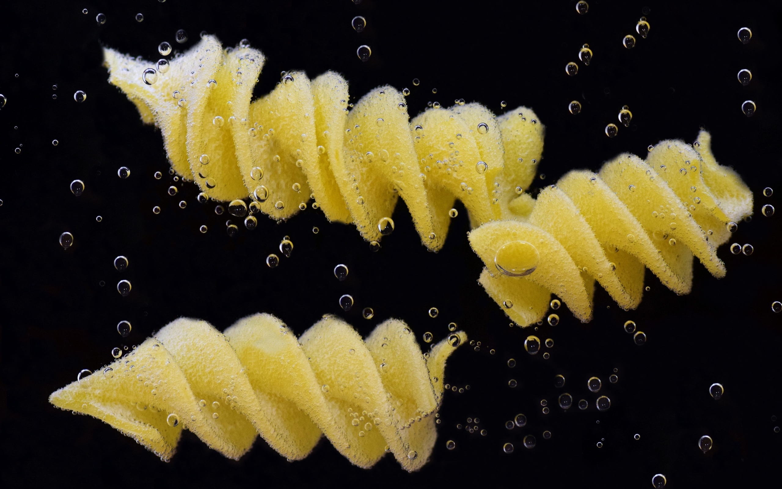 Макароны в воде на черном фоне