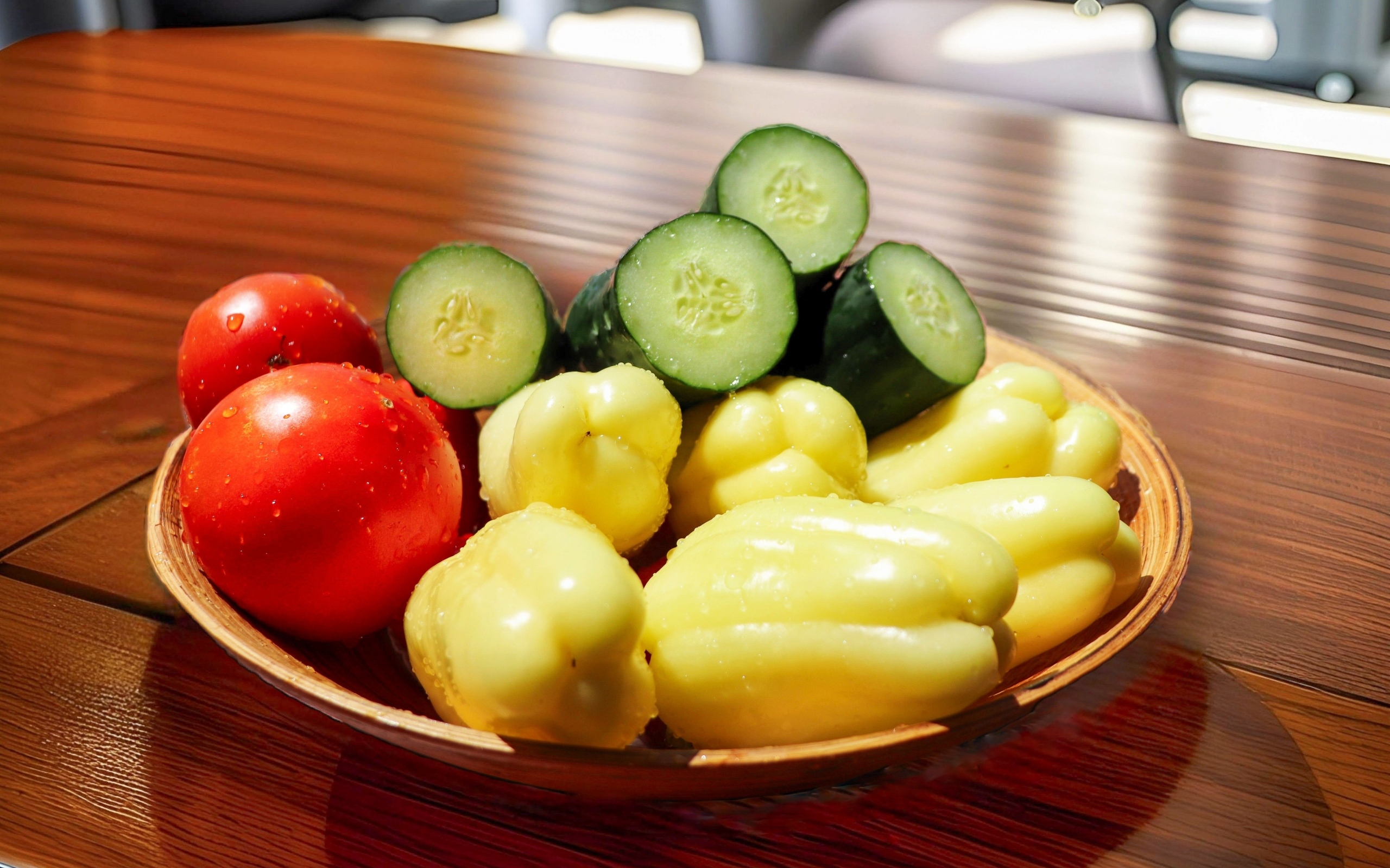 Перец, помидоры и зеленые огурцы на тарелке на столе