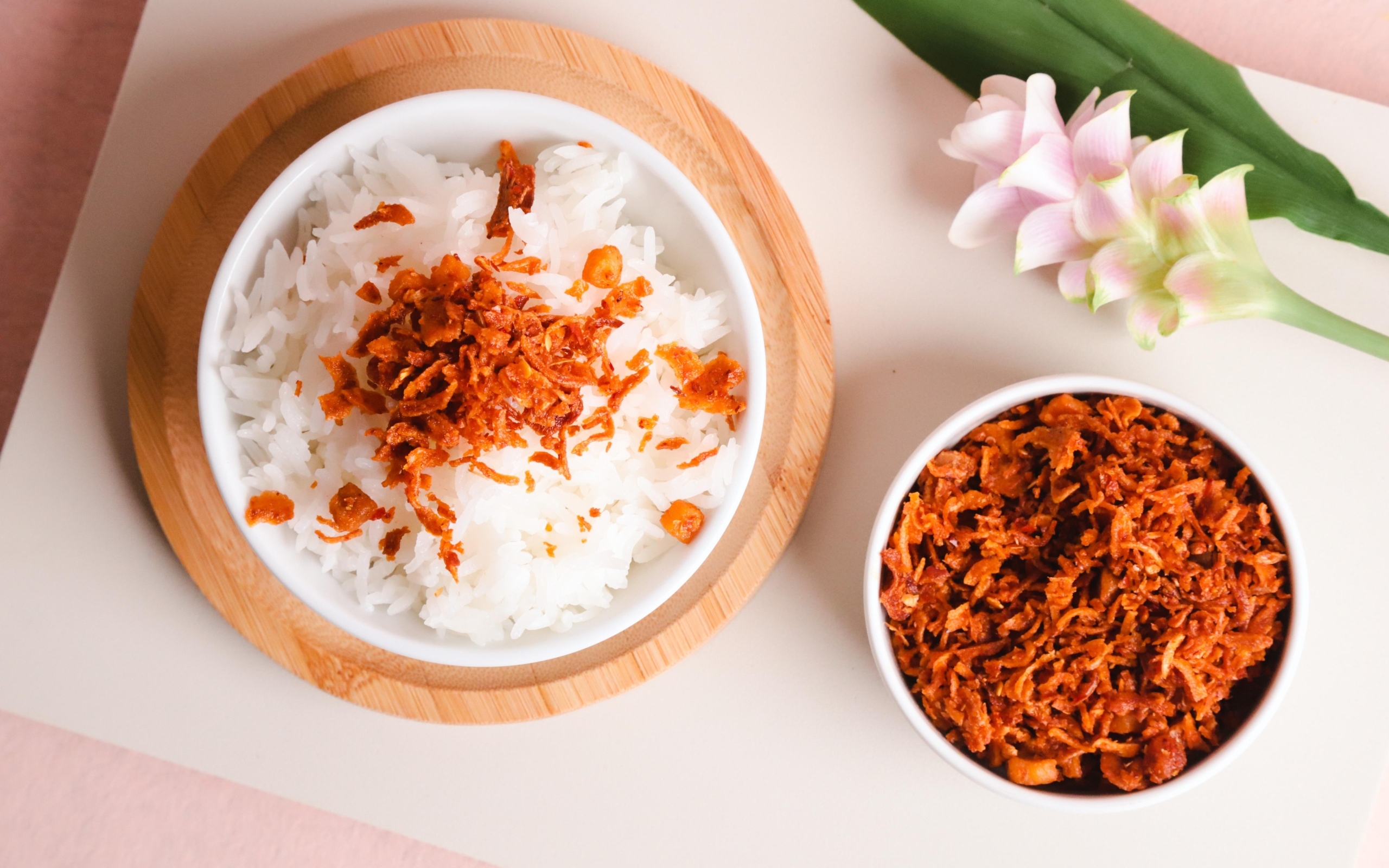 Рис с луком на столе с цветком