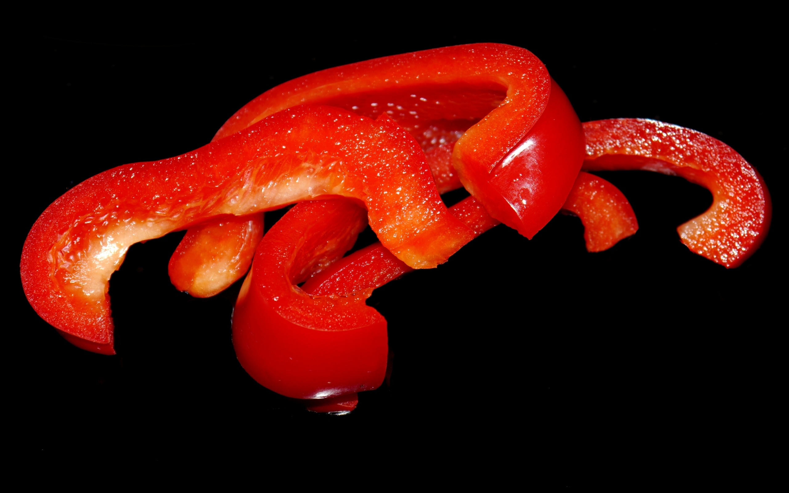 Нарезанный сладкий красный перец на черном фоне