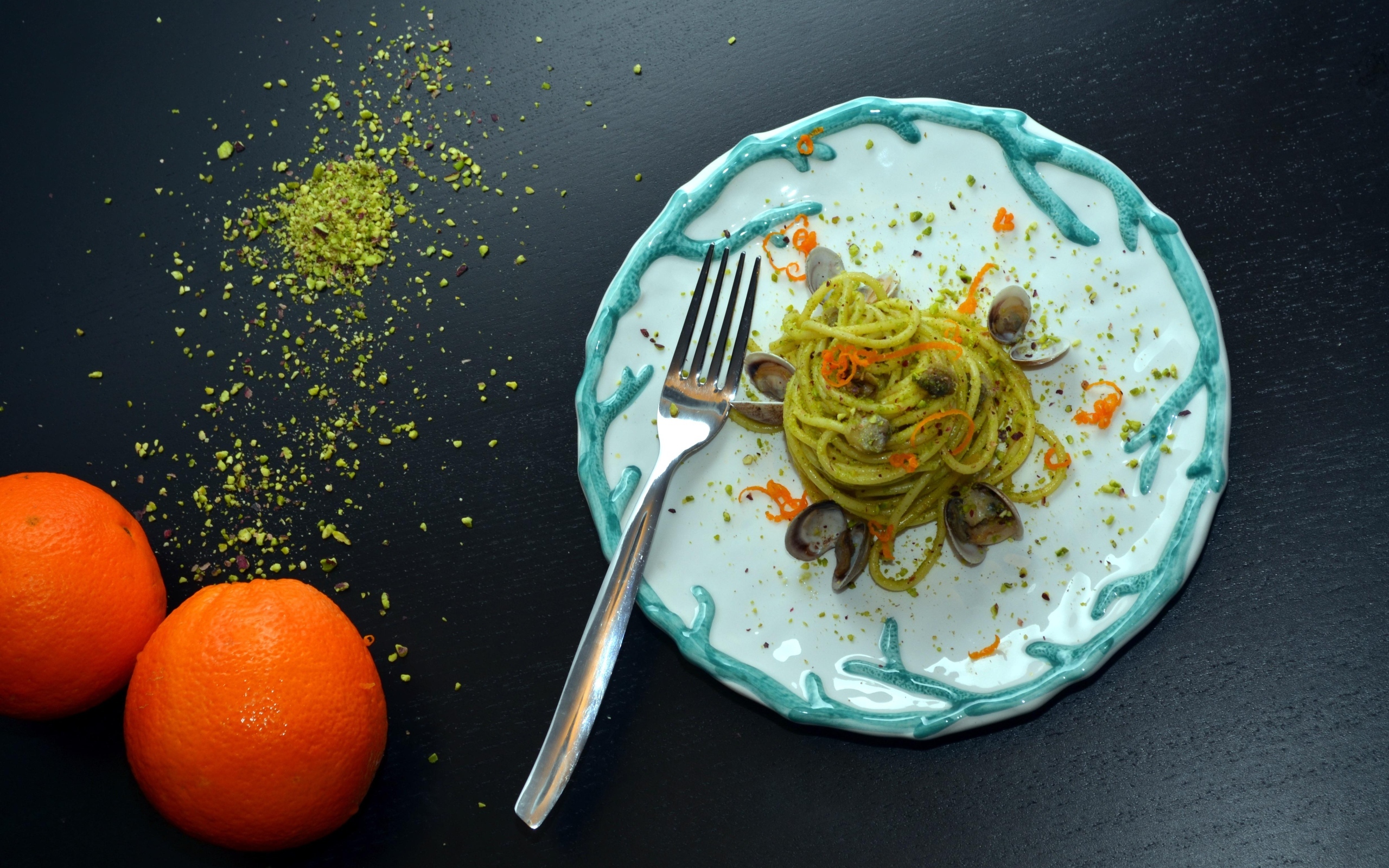 Спагетти с морепродуктами на столе с апельсинами