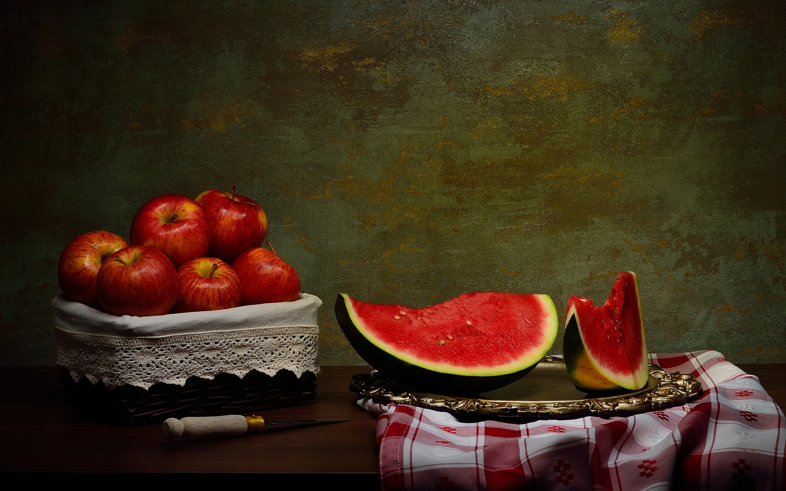 Скибки арбуза на столе с яблоками 