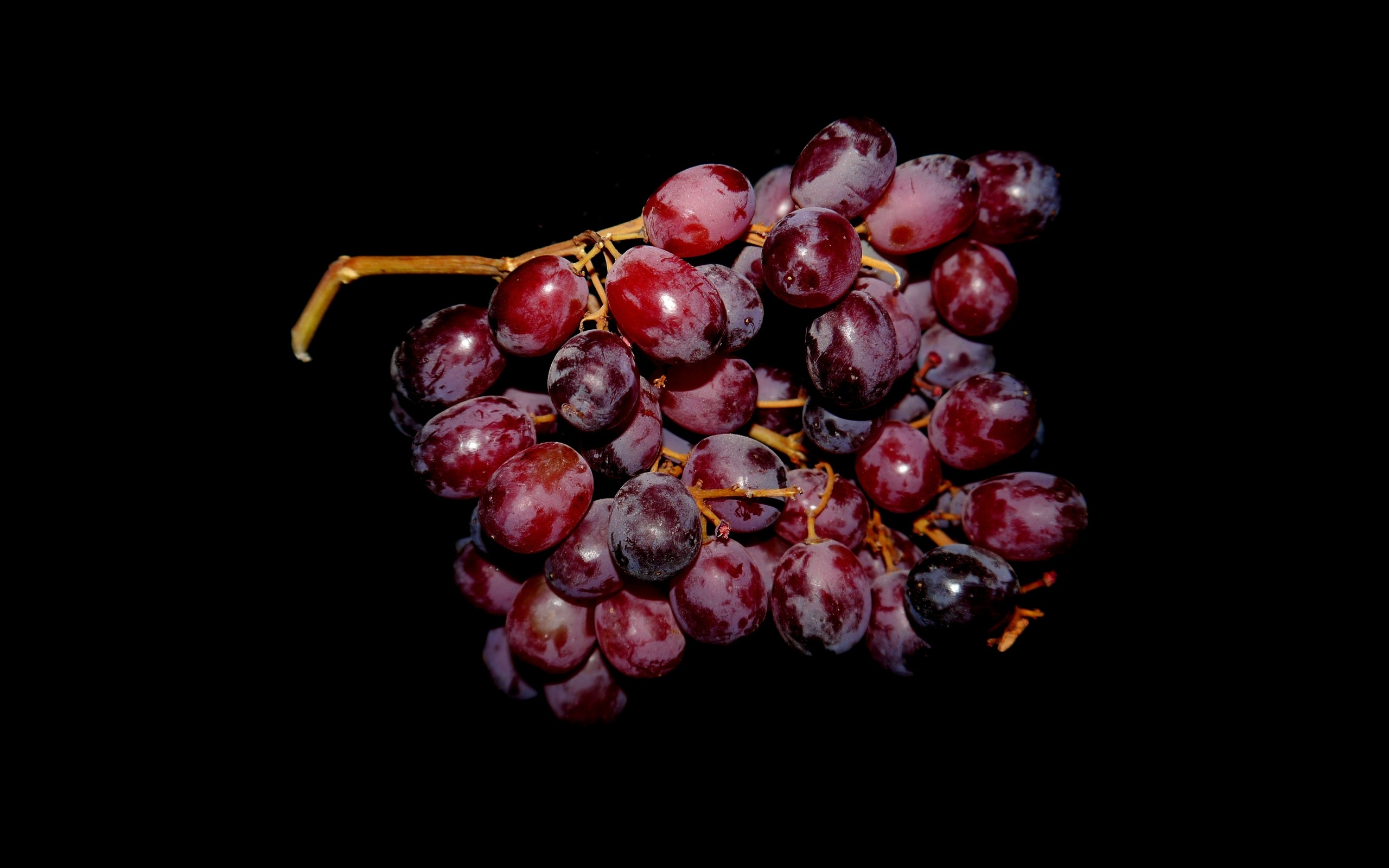 Гроздь розового винограда на черном фоне