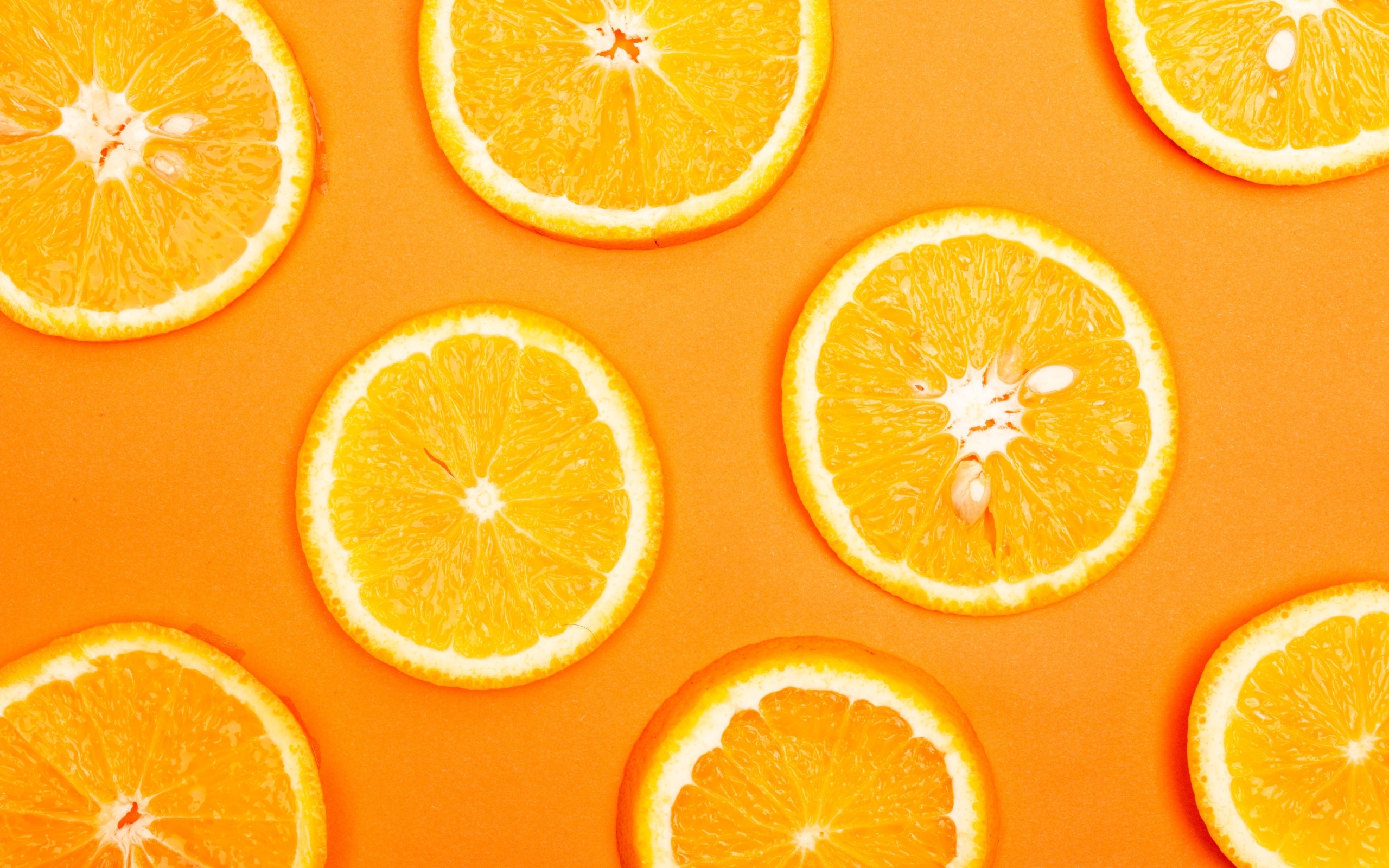 Спелый апельсин на оранжевом фоне